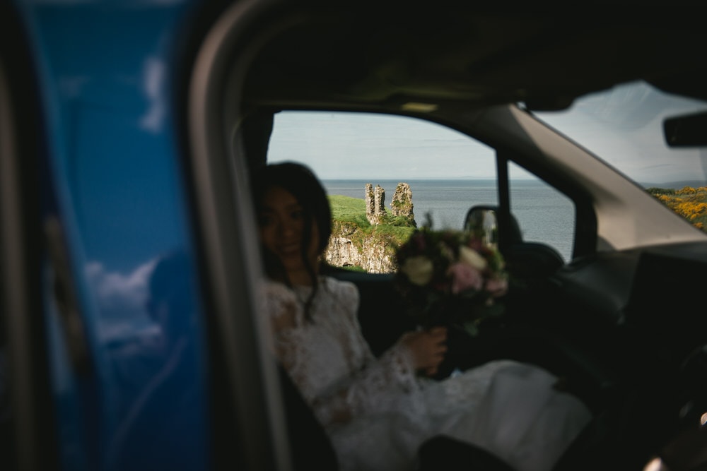 Candid shot of the bride in the car discovering the dunseverick castle on her elopement day in northern ireland