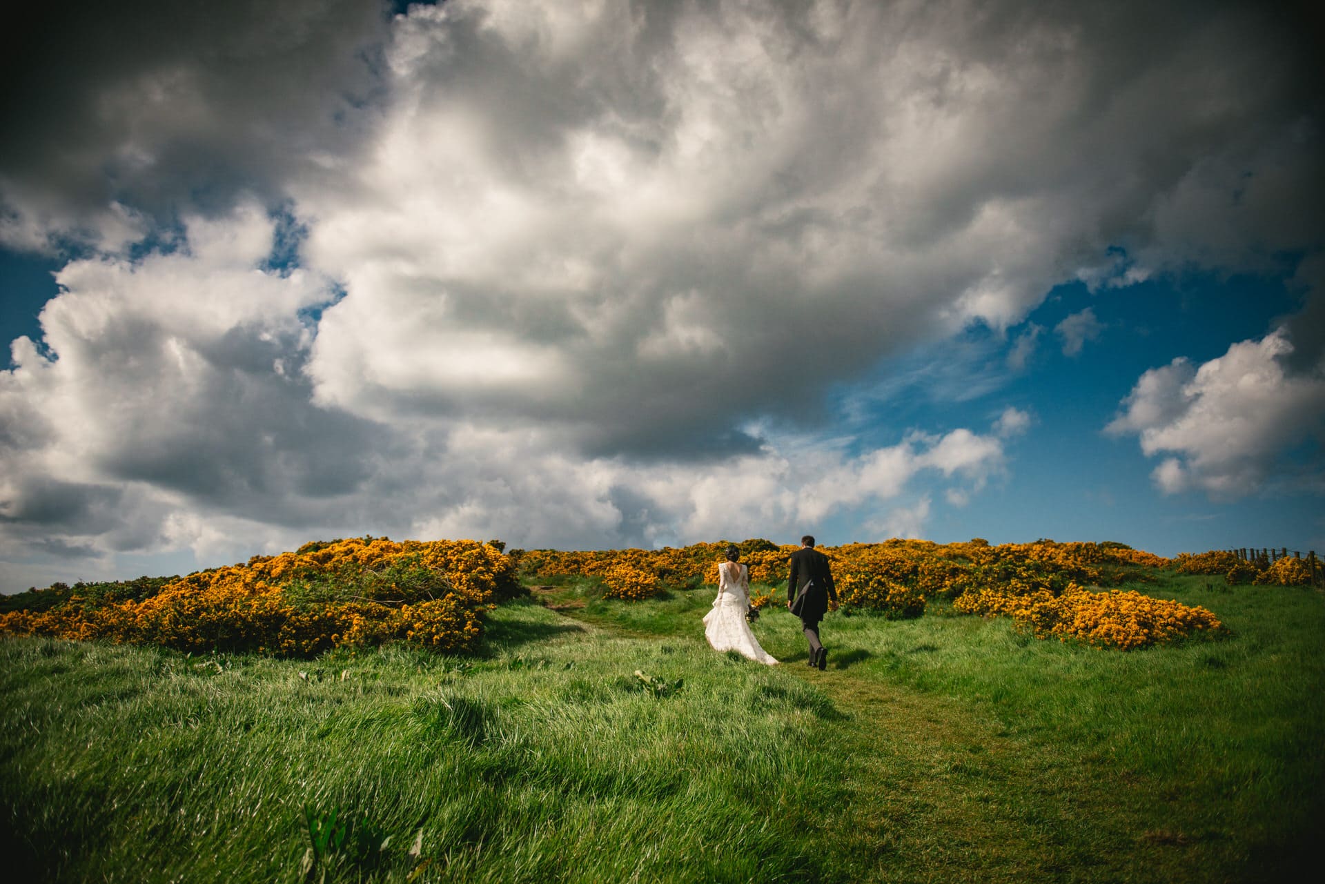Enchanting shot of the couple strolling through a vibrant flower garden during their Northern Ireland elopement.