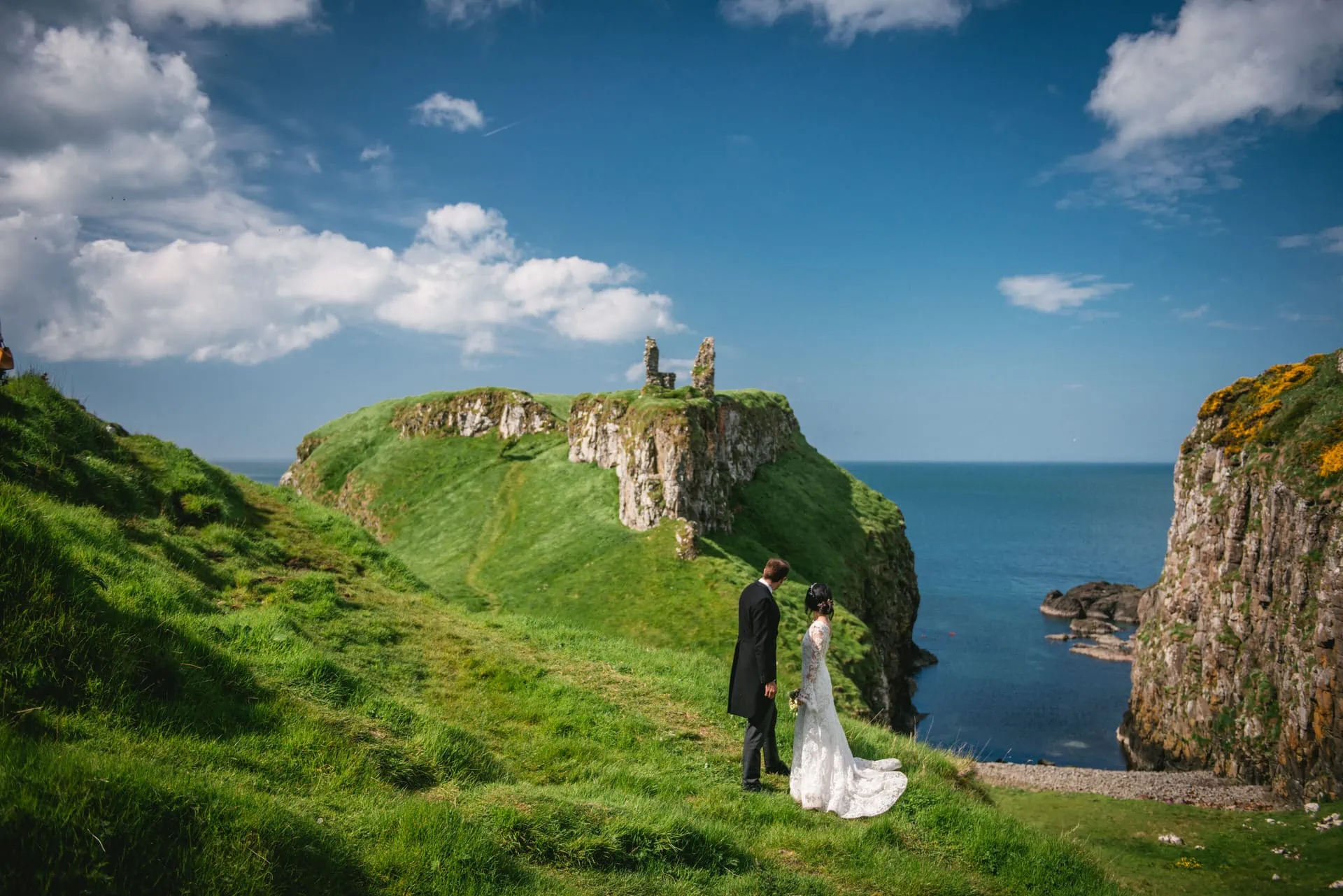 The bride and groom sharing a romantic moment in front of an ancient stone wall during their Northern Ireland elopement.