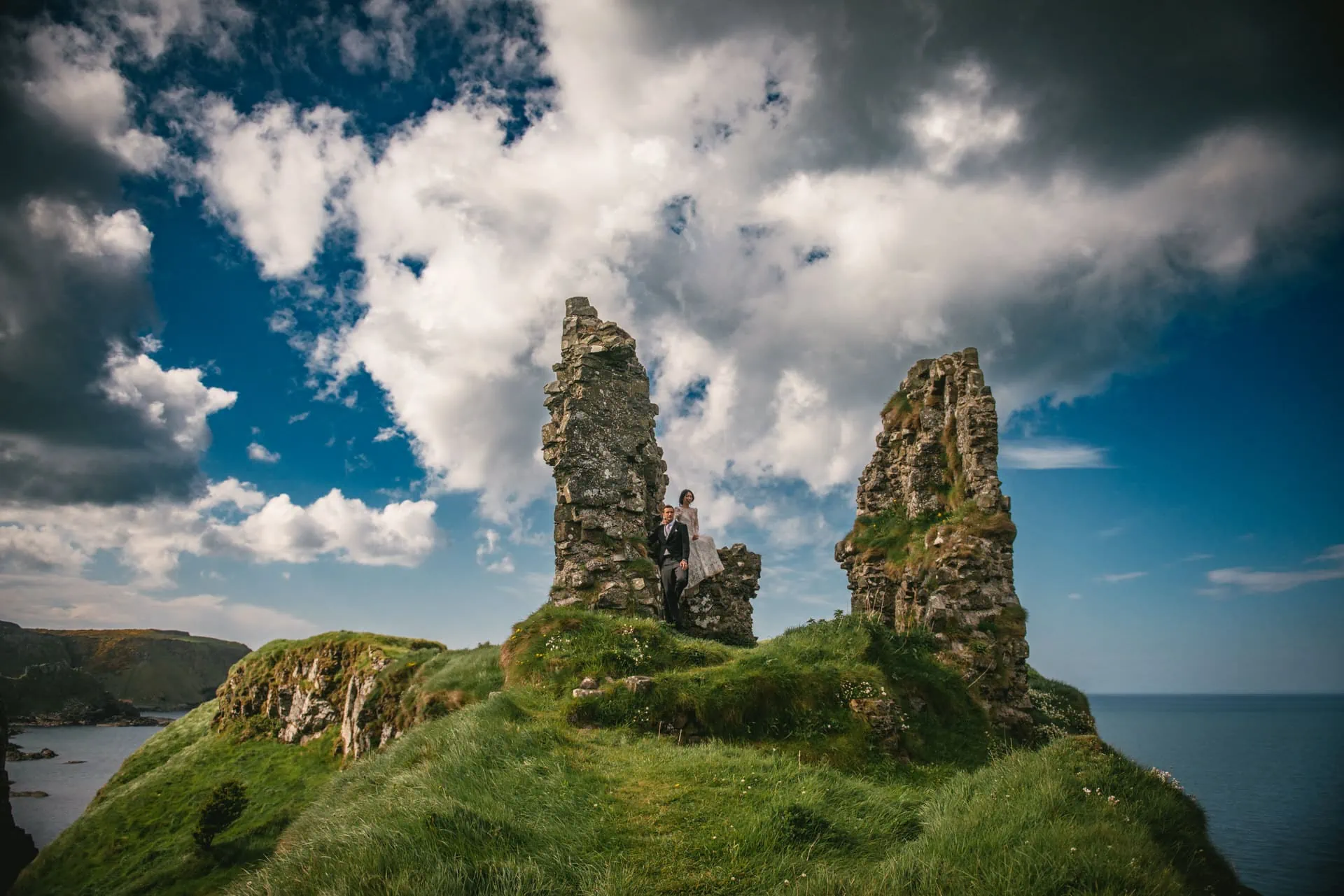 The couple framed by a stone archway at the castle ruins during their Northern Ireland elopement.
