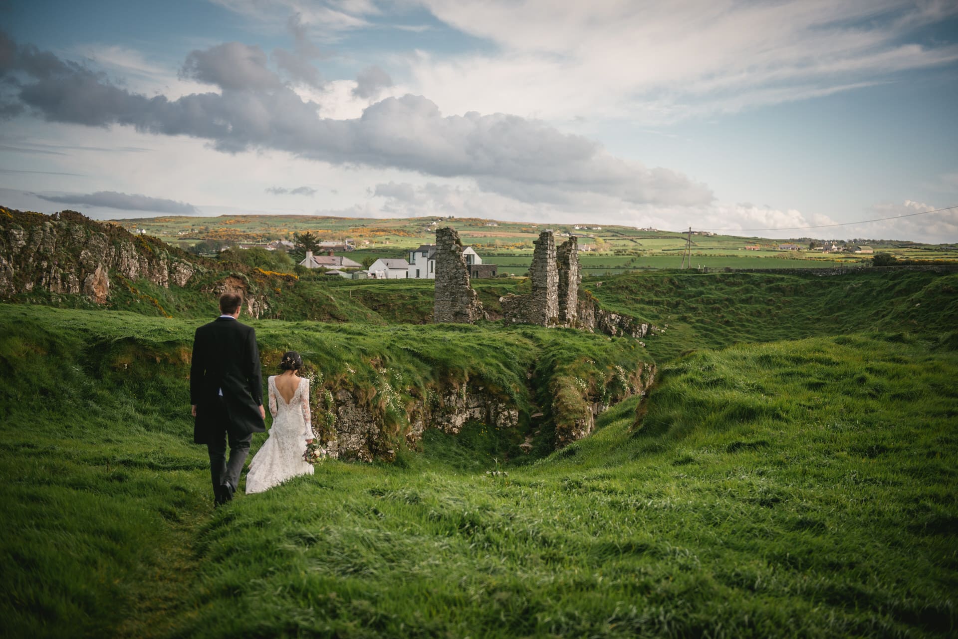 The bride's breathtaking lace train flowing behind her as she walks during their Northern Ireland elopement.