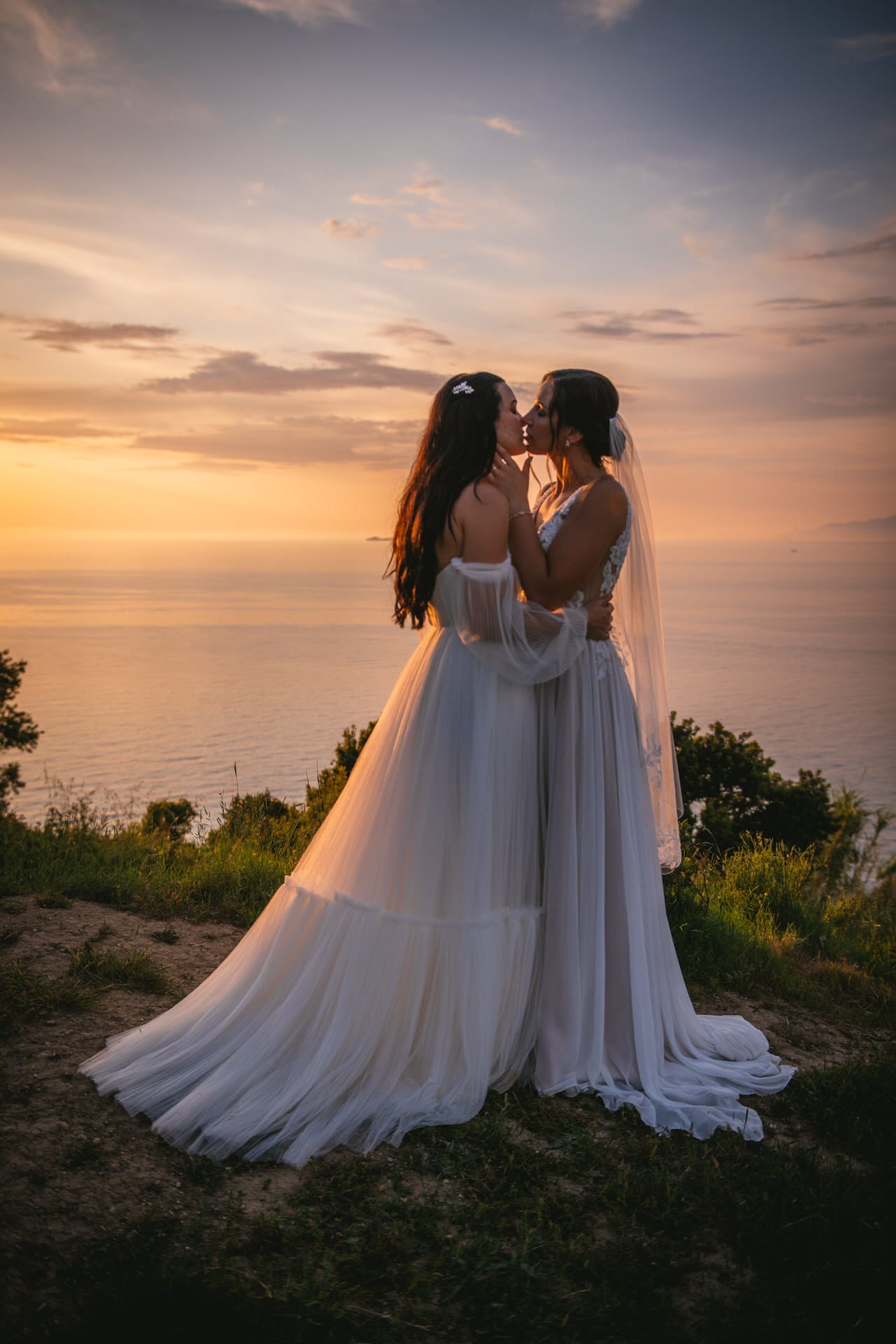 Brides sharing a loving kiss under the sunset, a romantic scene in Corfu elopement.