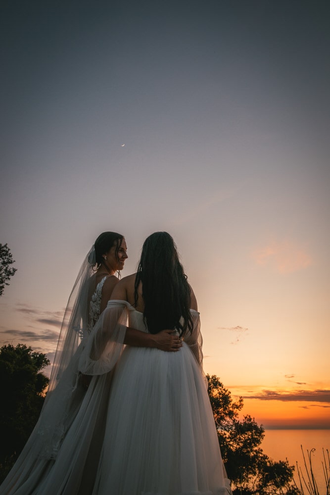 Embracing the moon's glow, the brides share a tender moment during their Corfu elopement.
