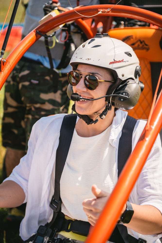 Detail of the bride's radiant smile as she prepares for an unforgettable paragliding experience.