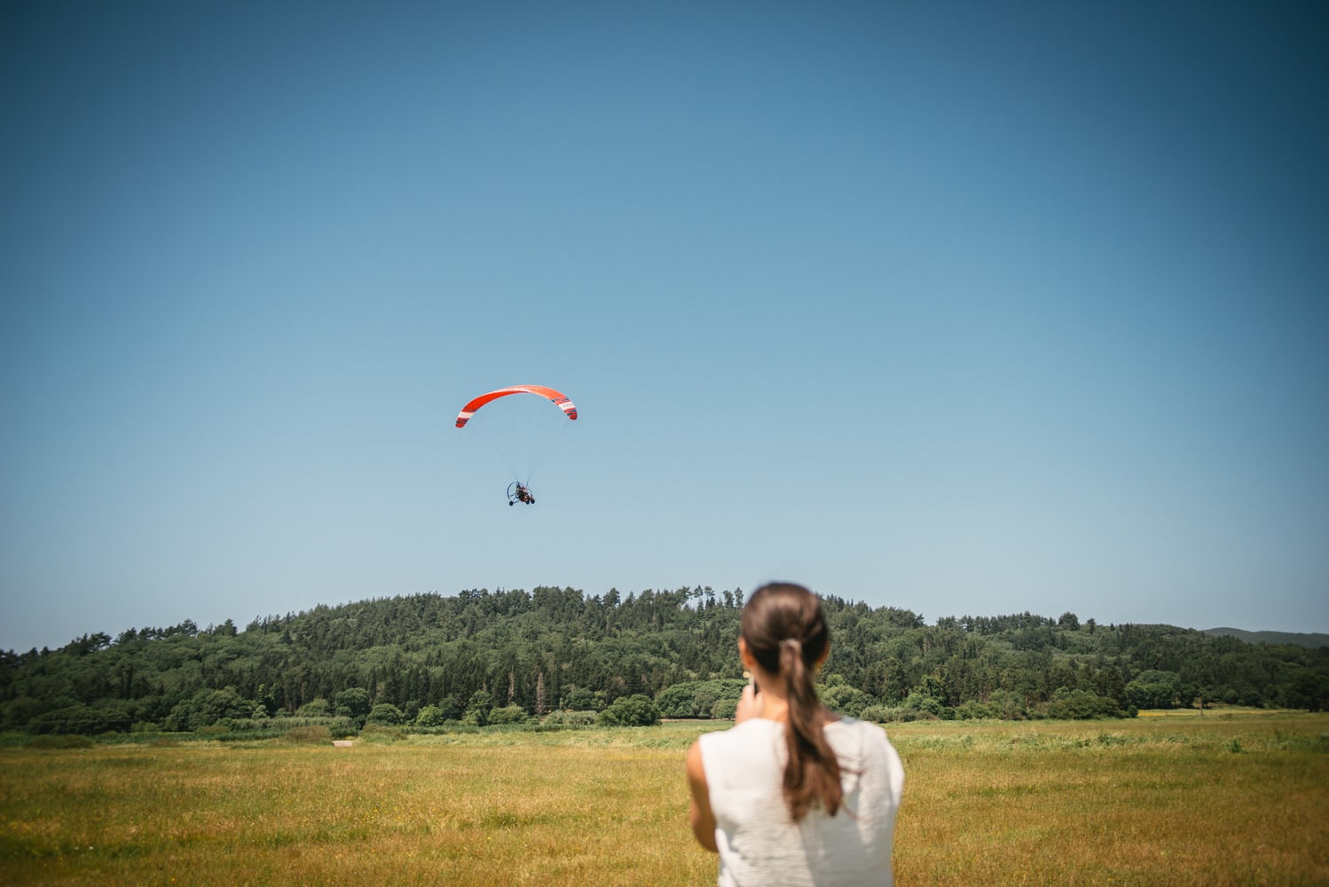 Bride's affectionate look as she watches her wife take off on a paraglider in Corfu.