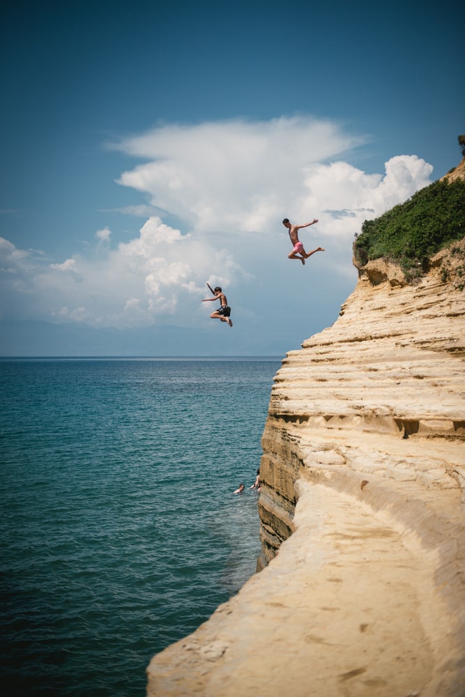 A daring cliff jump captured in the Corfu scenery, an exciting moment of their elopement.