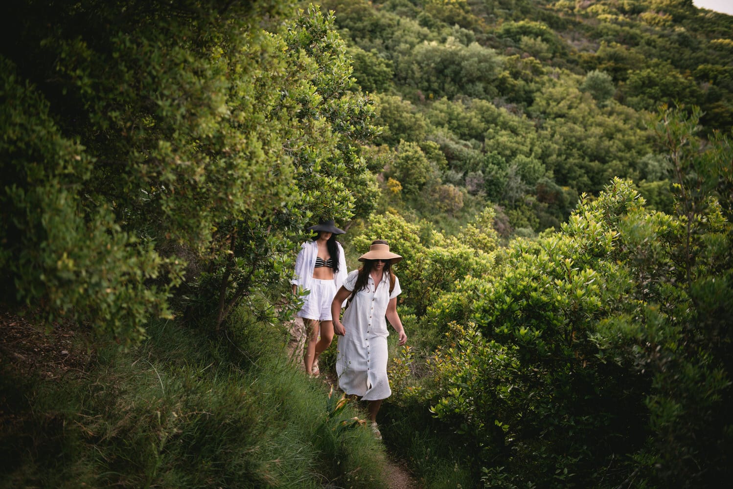 Brides enjoying a leisurely walk in the forest, a serene escape during their Corfu elopement.