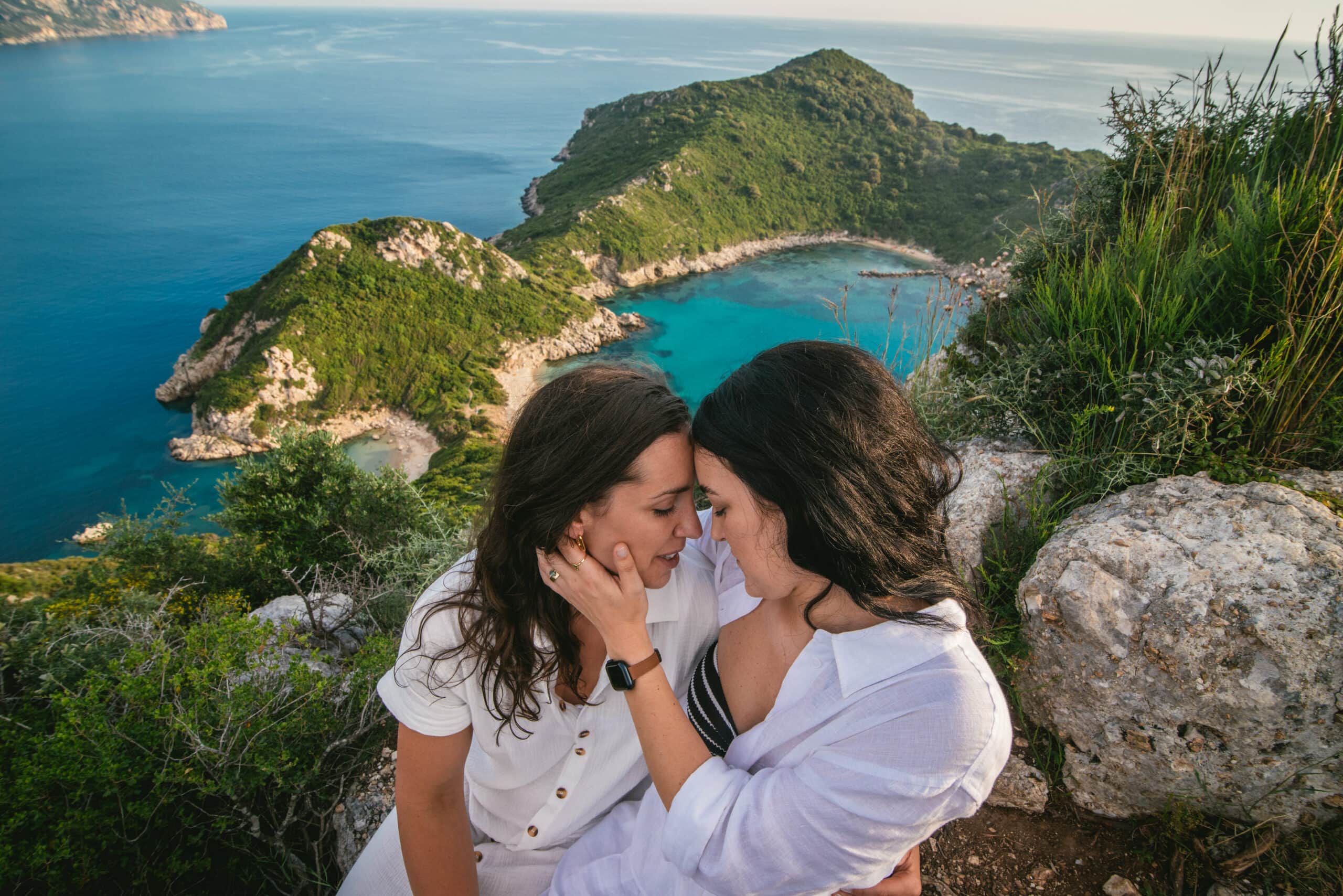 Brides sharing an intimate moment with foreheads touching during their Corfu elopement.