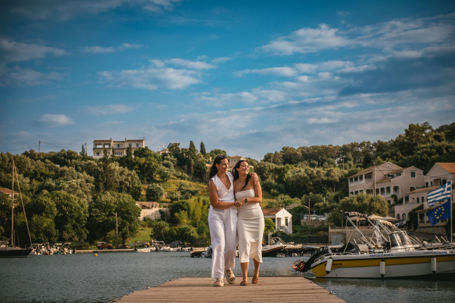 Coastal whispers: Brides walk along the shore, love's secrets carried by the waves during their Corfu elopement.