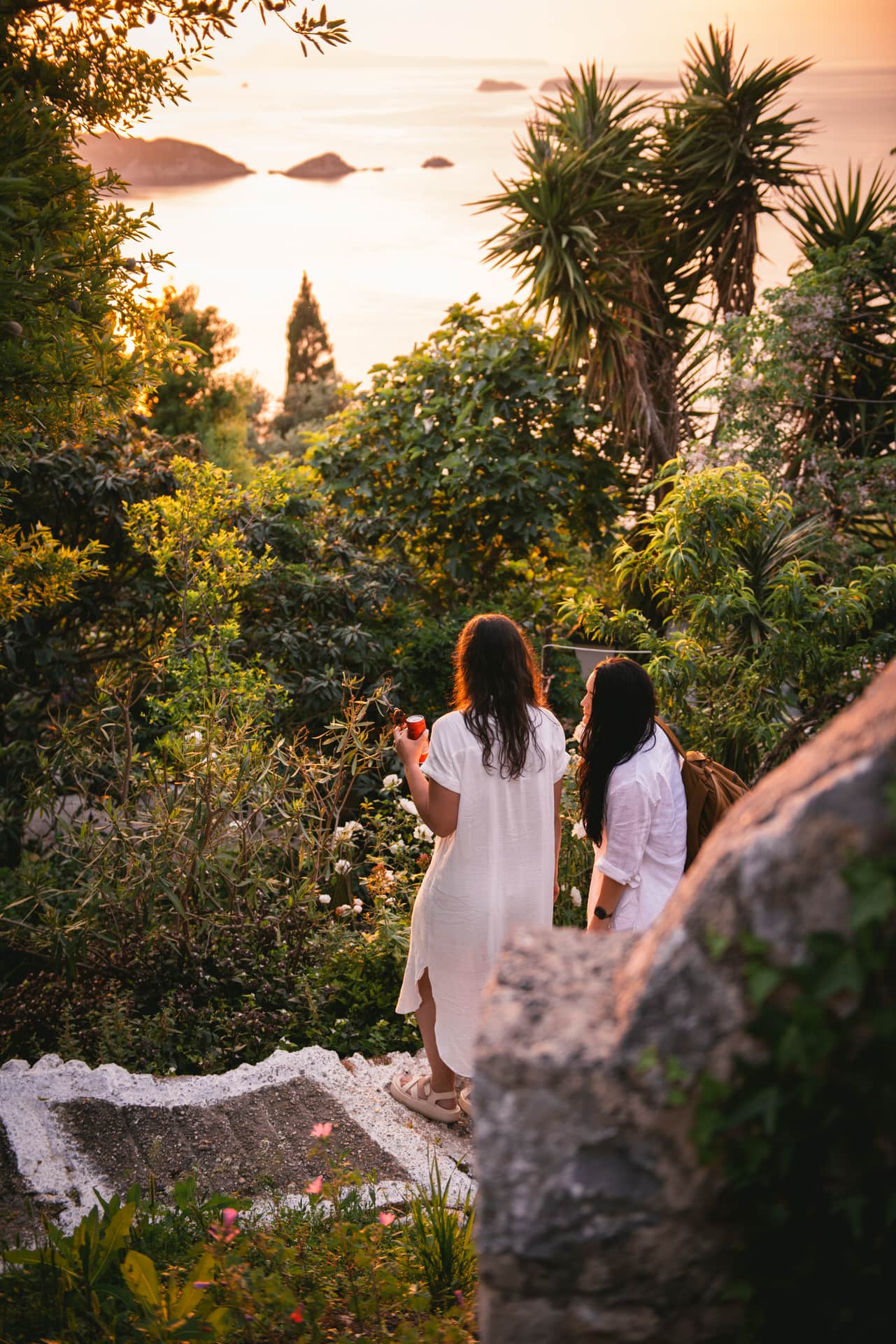 Brides enjoying the view, their connection reflected against the backdrop of a captivating Corfu sunset.
