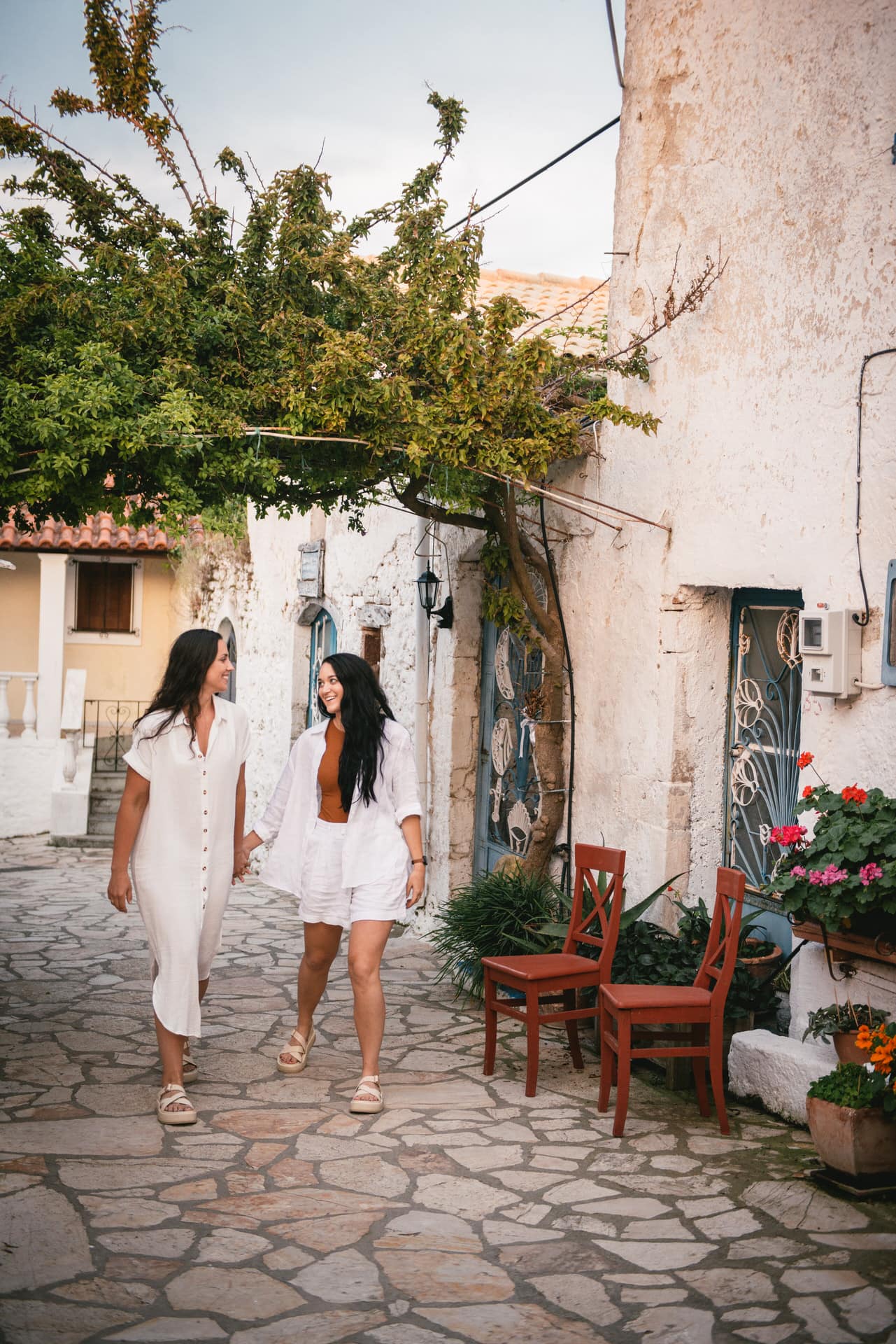 Brides holding hands while strolling through the picturesque streets, cherishing their Corfu elopement.
