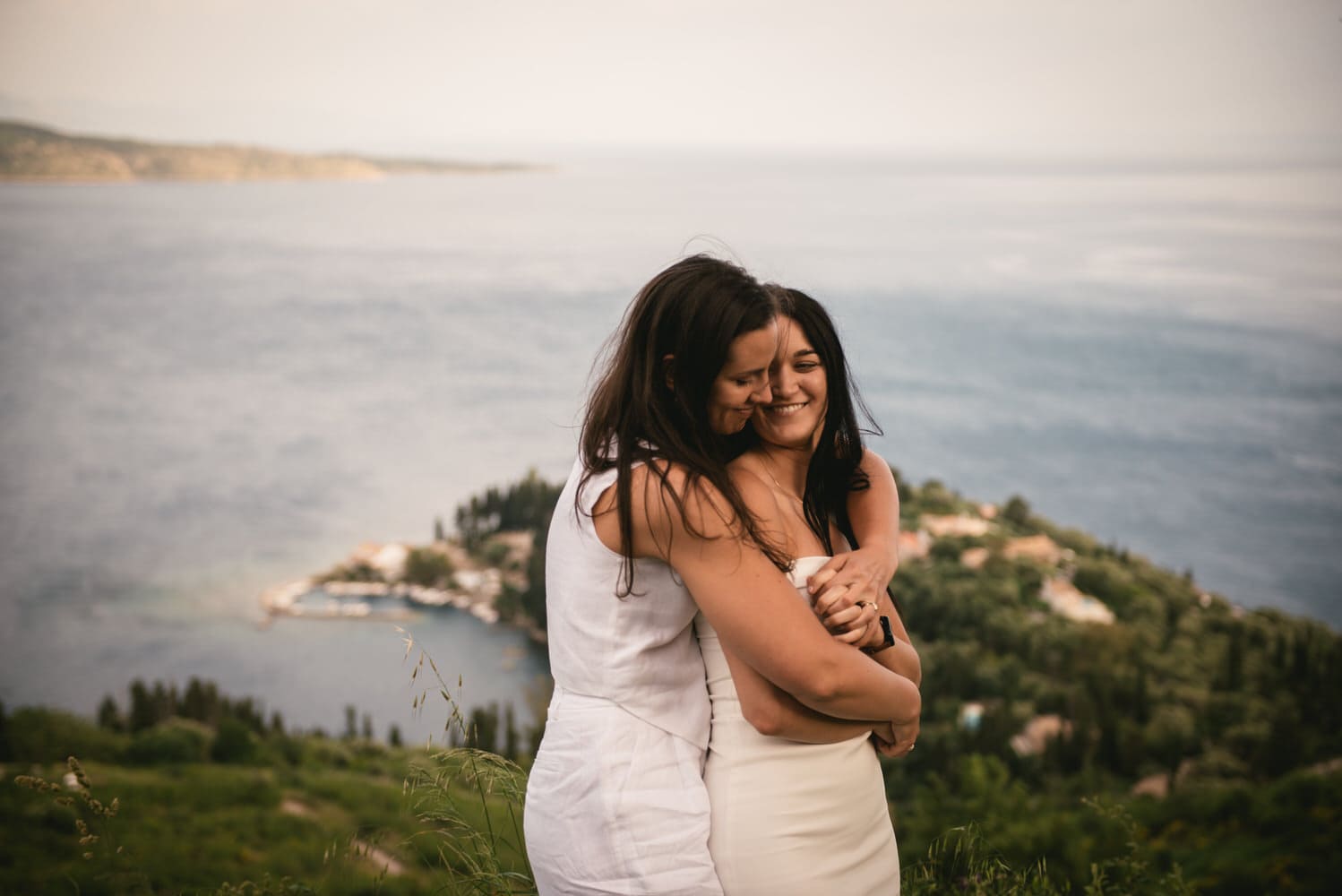 Seaside embrace: Brides walk along the shore, love's journey carried by the waves during their Corfu elopement.