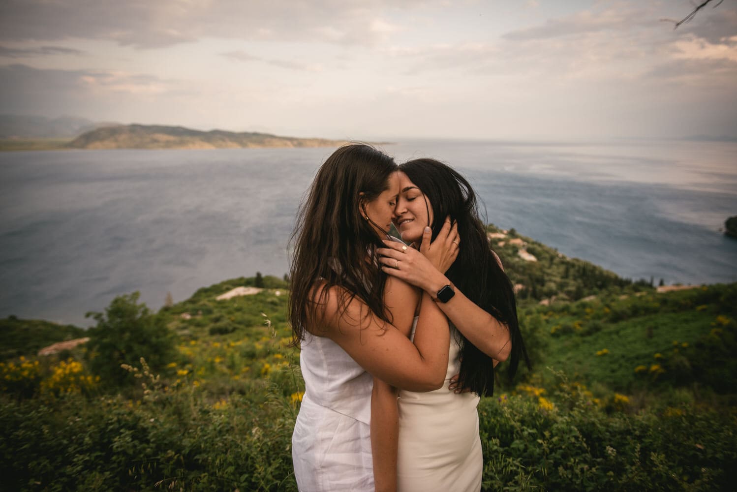 Seaside harmony: Brides walk along the shore, love's rhythm echoed by the waves during their Corfu elopement.