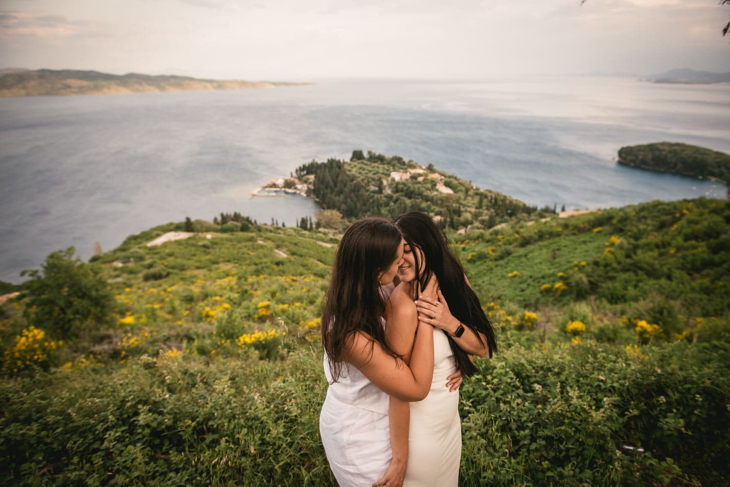 Seaside echoes: Brides walk along the shore, love's whispers carried by the waves during their Corfu elopement.