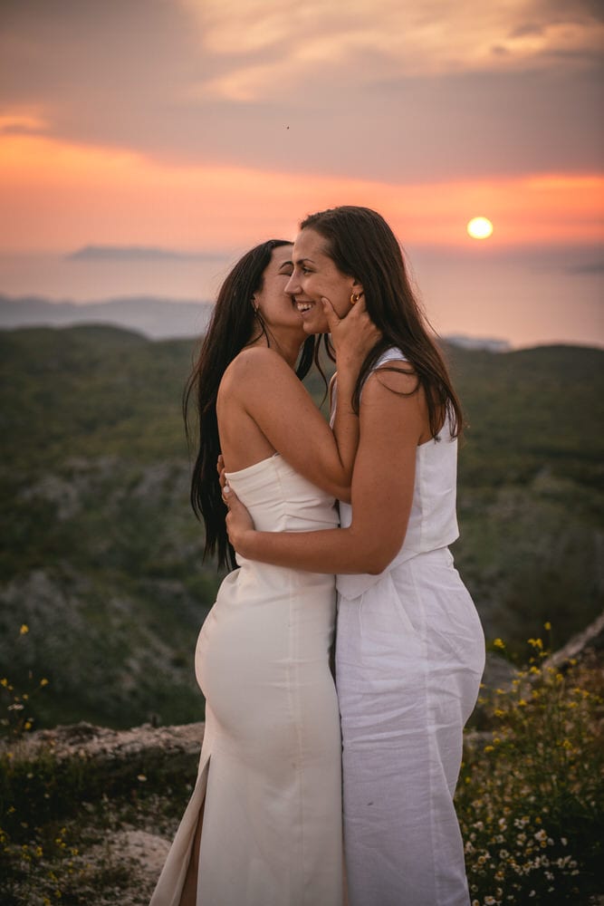 Brides sharing a kiss as the sun sets on their romantic Corfu elopement.