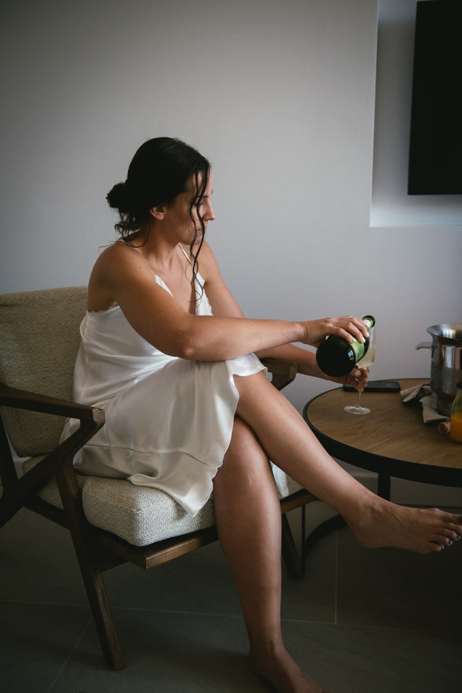 Bride pouring a mimosa, toasting to love on their Corfu elopement.