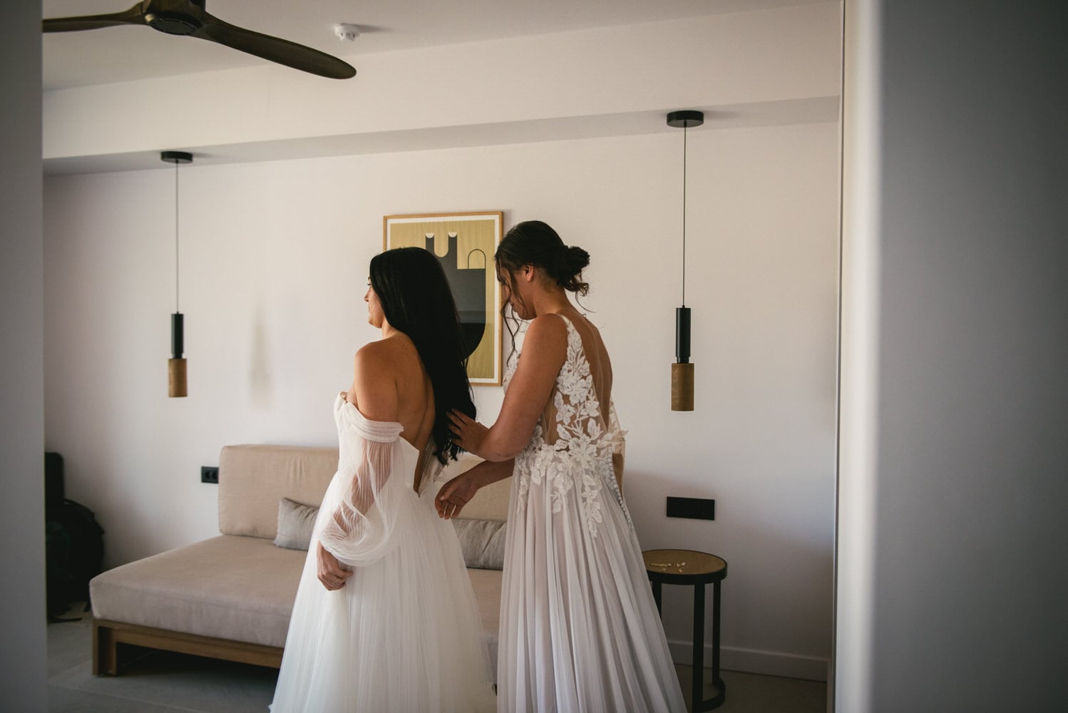 One bride helping the other with her dress, shared moments before their Corfu elopement.