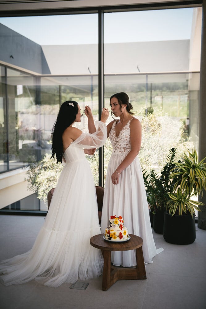 Brides savoring cake, sweetness in every bite of their Corfu elopement.