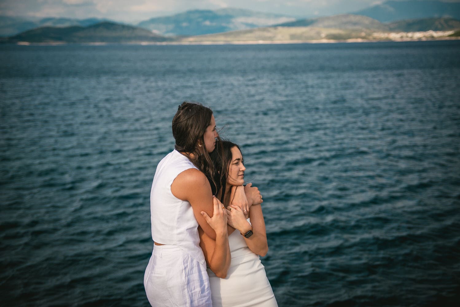 Coastal embrace: Brides walk along the shore, love's journey carried by the waves during their Corfu elopement.