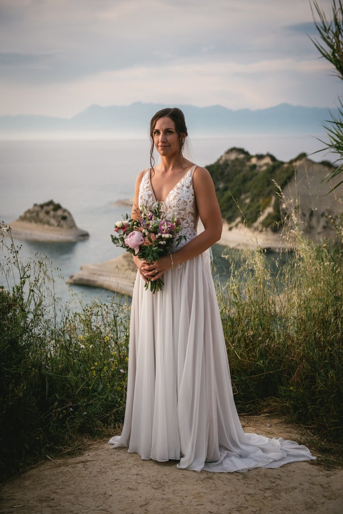 Portrait of a bride framed by the cliffs, strength and beauty in her Corfu elopement.