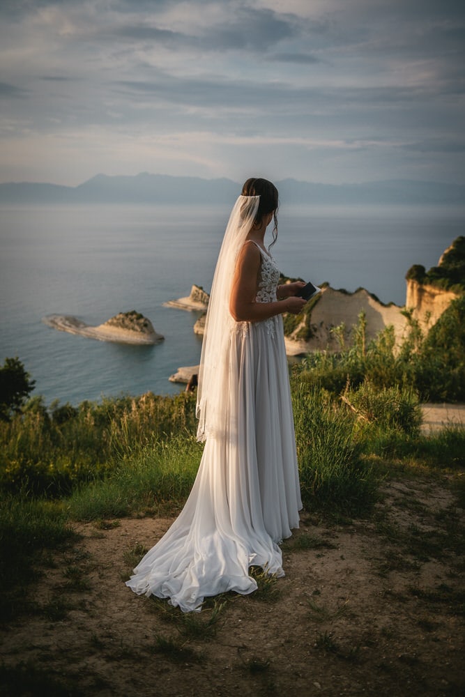 Bride overlooking the cliffs, contemplation and beauty in her Corfu elopement.