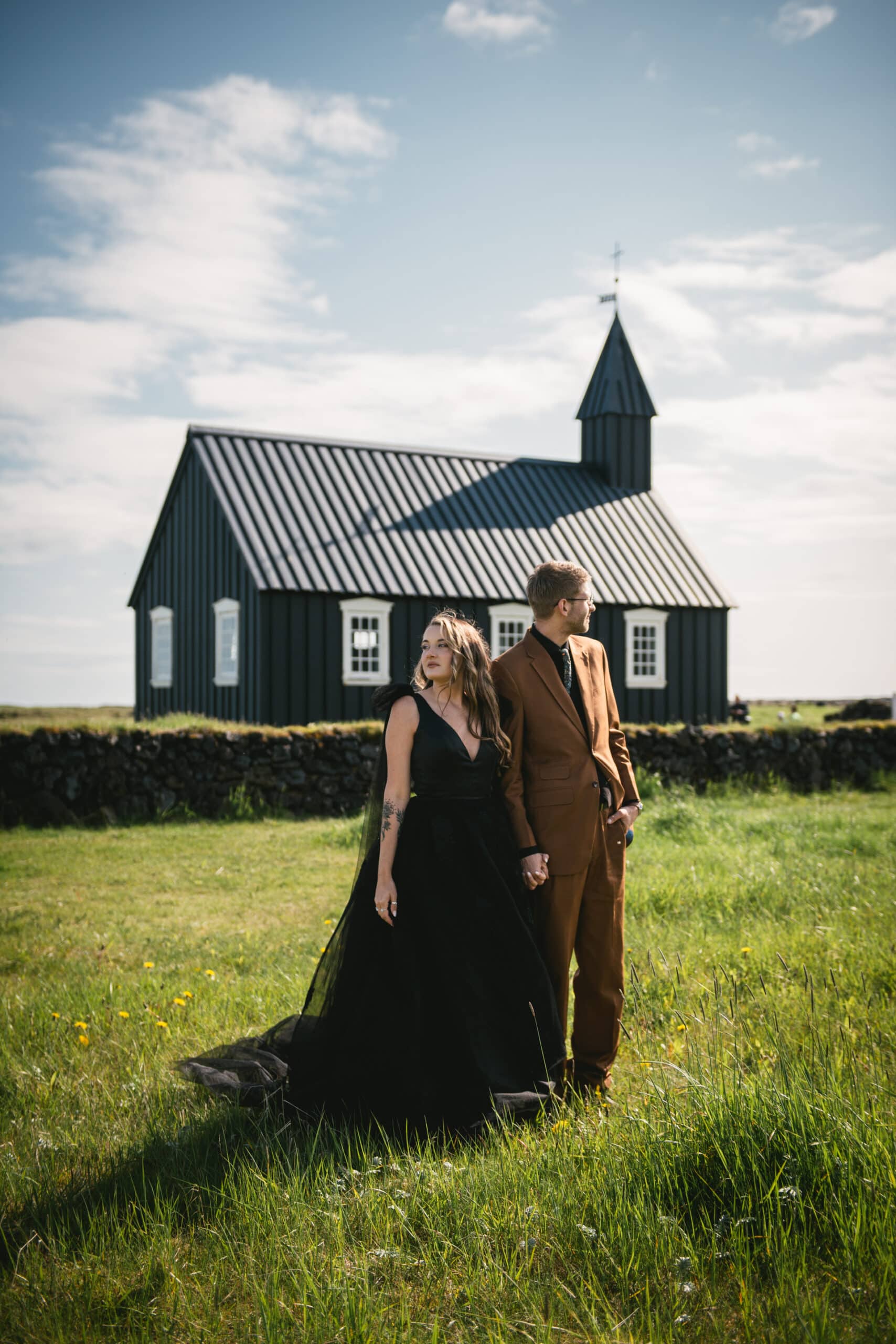 A romantic embrace captured in front of the historic Church of Budir during their Iceland Westfjords elopement.