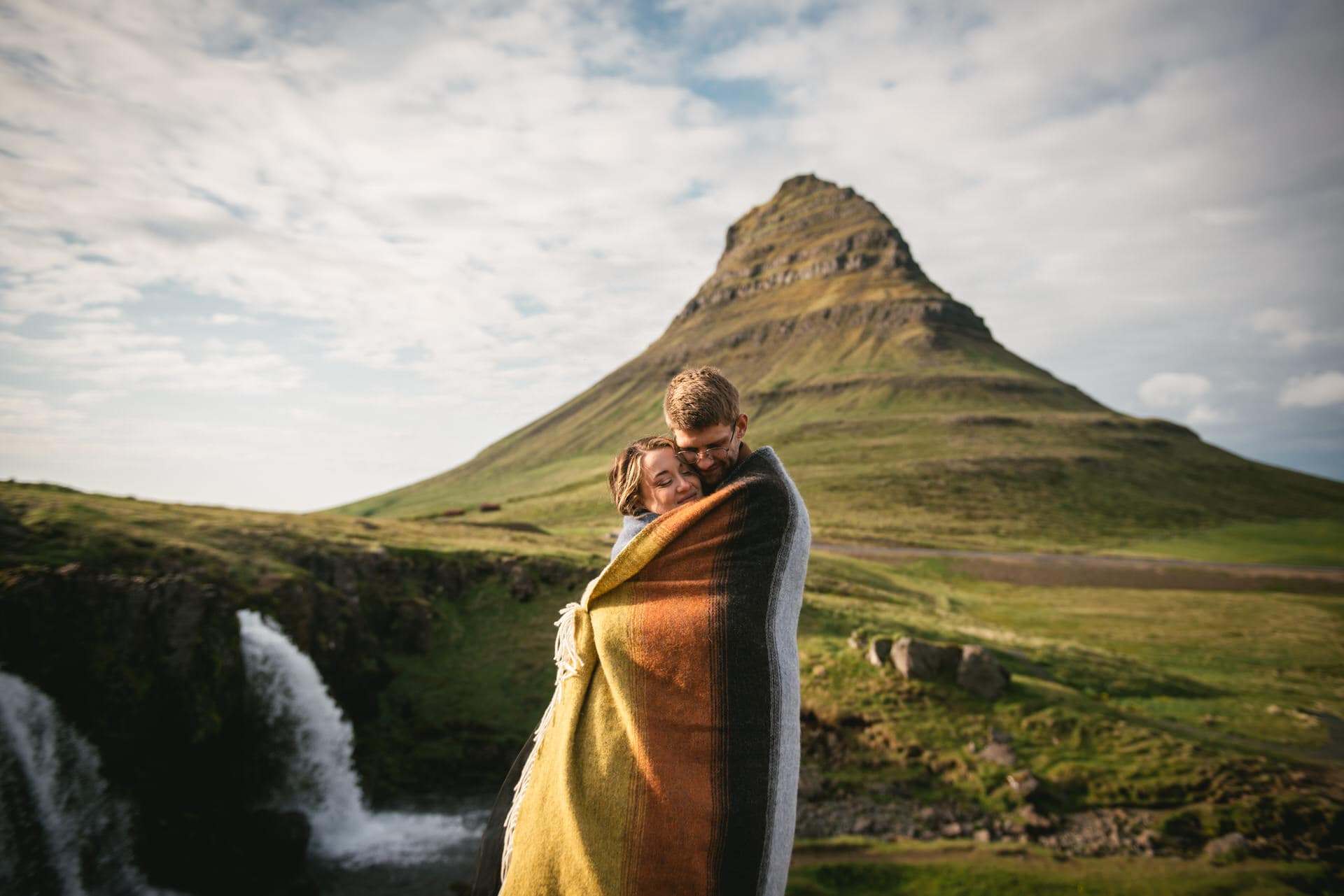 Serene embrace captured against the backdrop of an Icelandic waterfall.