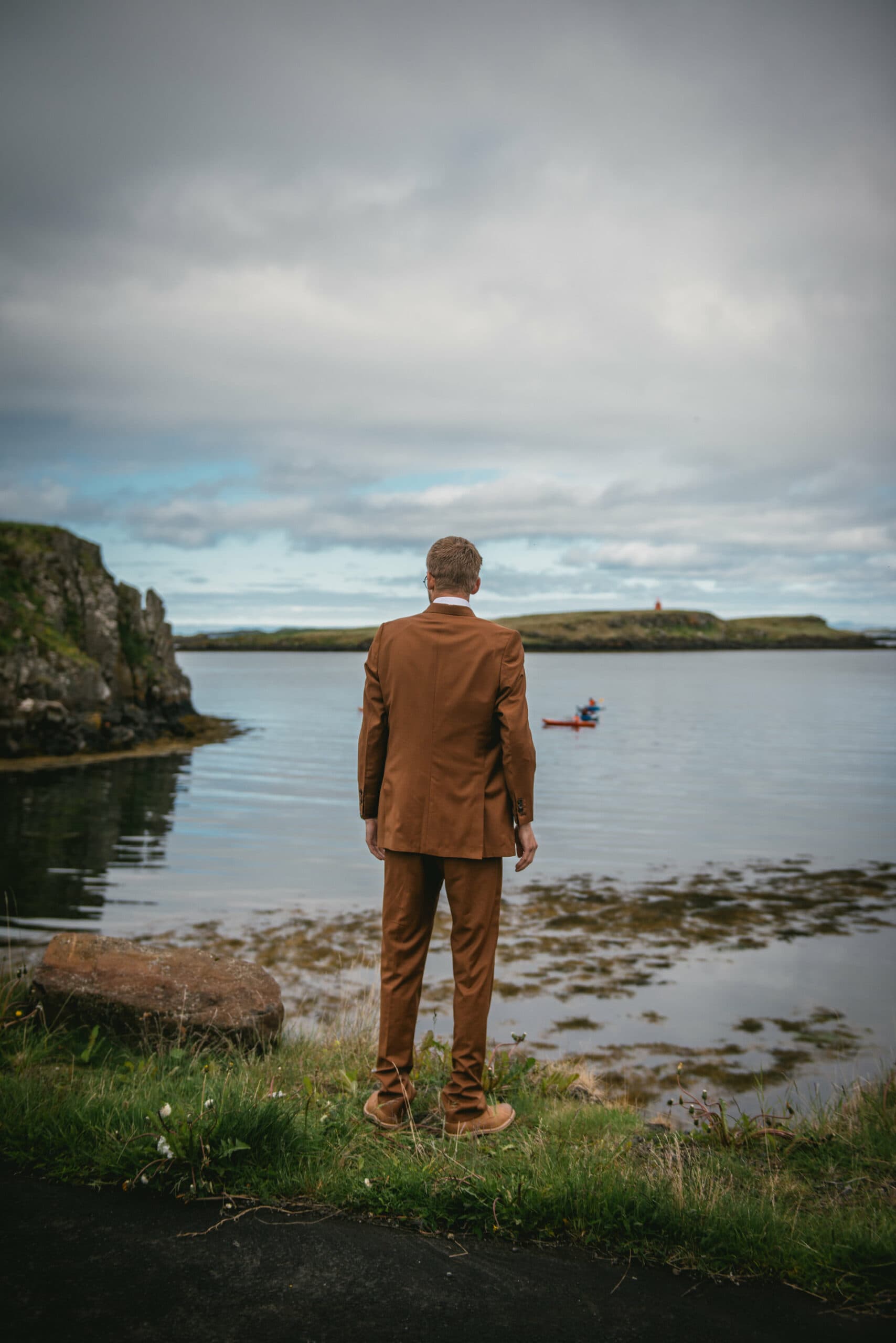 The groom's heart races with eager anticipation as he awaits the first look, surrounded by the enchanting allure of their Iceland Westfjords elopement.