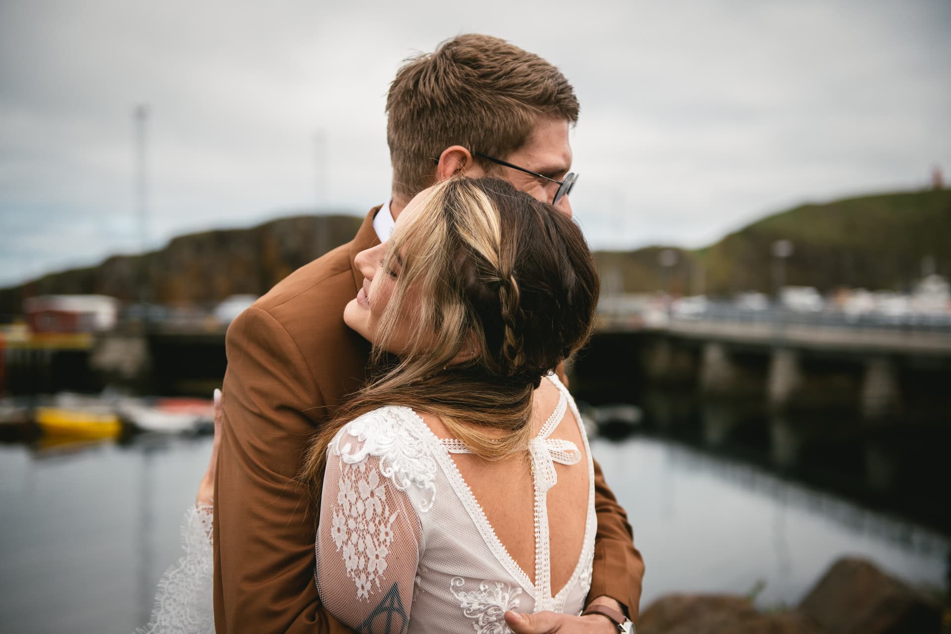 Bride and groom embrace amid the charm of a quaint Icelandic village.