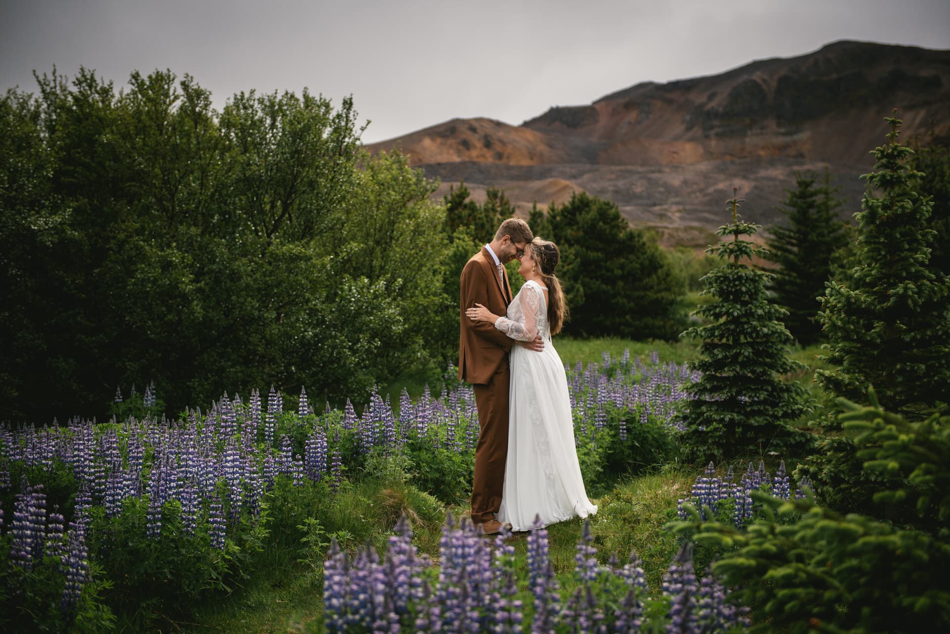 Bride and groom surrounded by the wildflowers of the Westfjords' meadows.