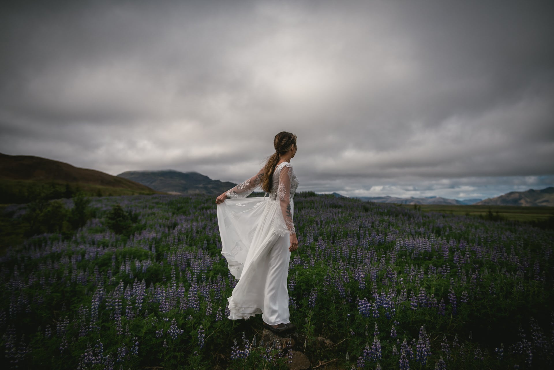 Dramatic shot of the bride's dress billowing in the wind against a dramatic Icelandic landscape.