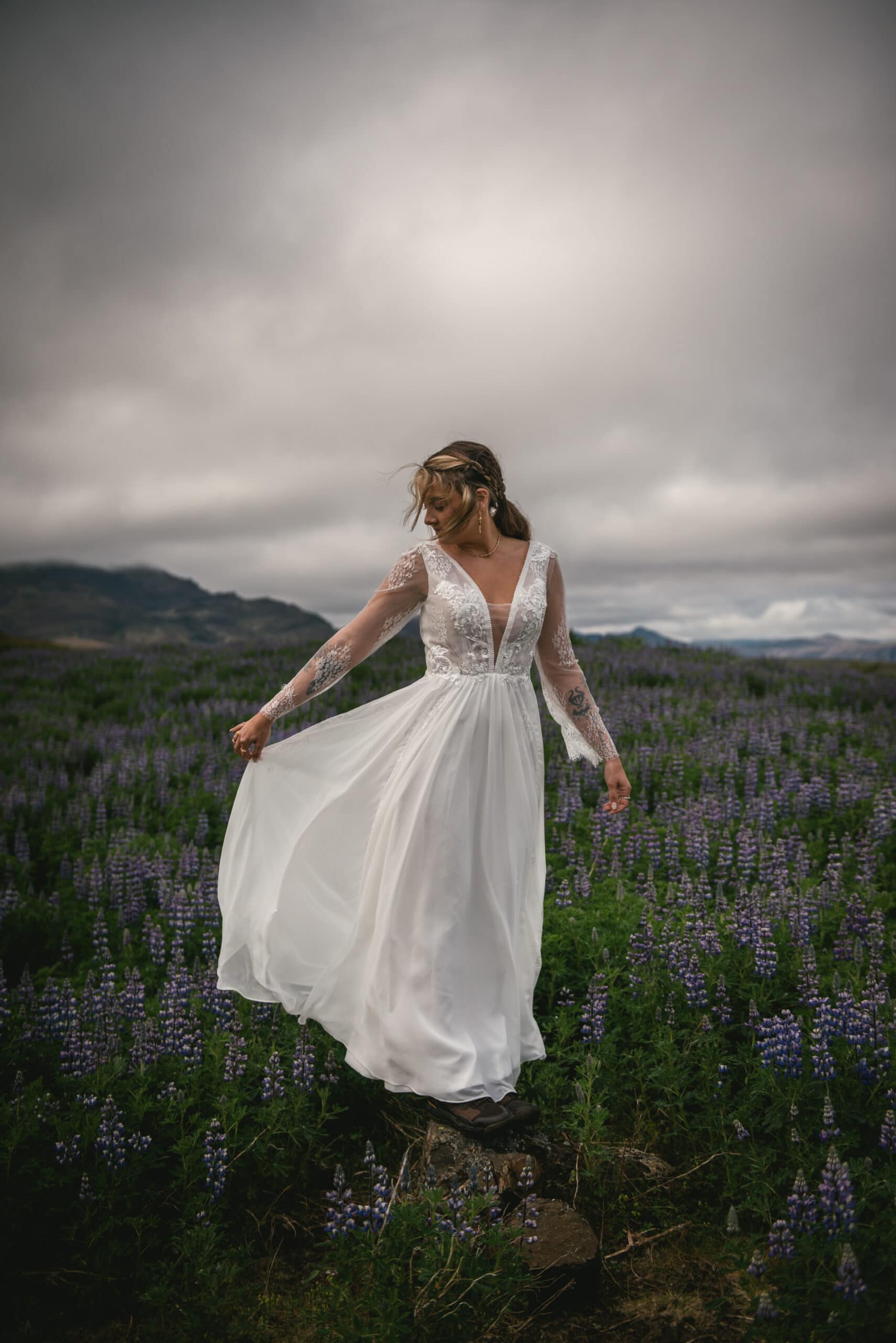 Bride's veil billows in the wind as she gazes out over the awe-inspiring Westfjords.