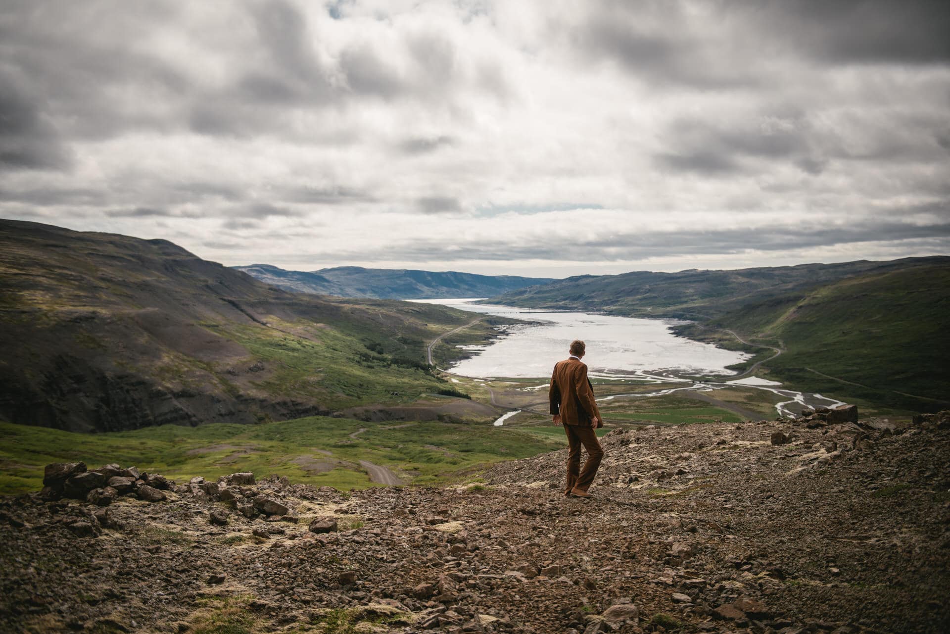 Captured from behind, the groom stands against the stunning backdrop of the Westfjords, a symbol of his upcoming Iceland elopement adventure.