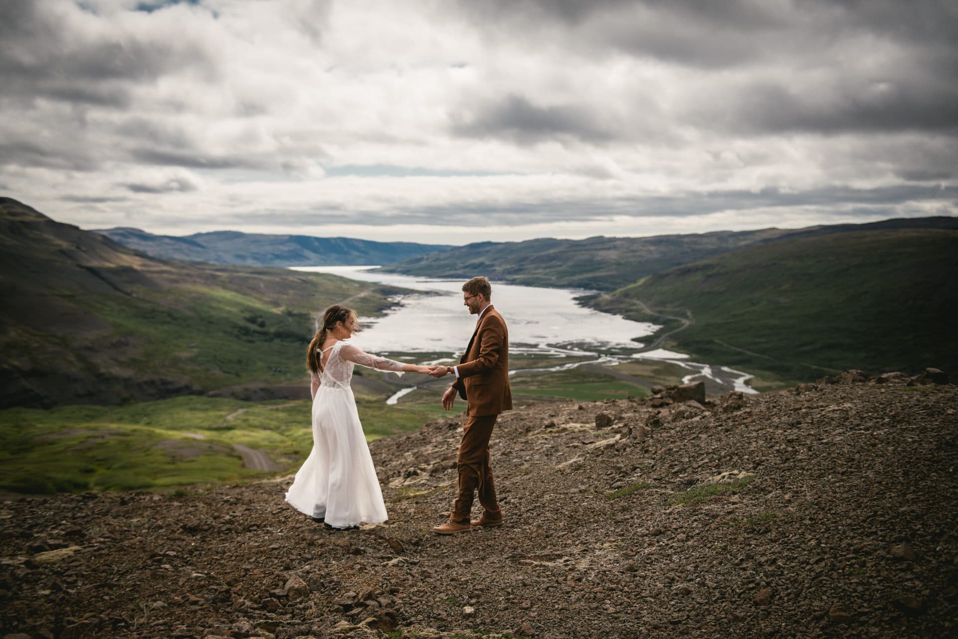 Whimsical photo as the couple dances on a coastal cliff during their Iceland elopement.