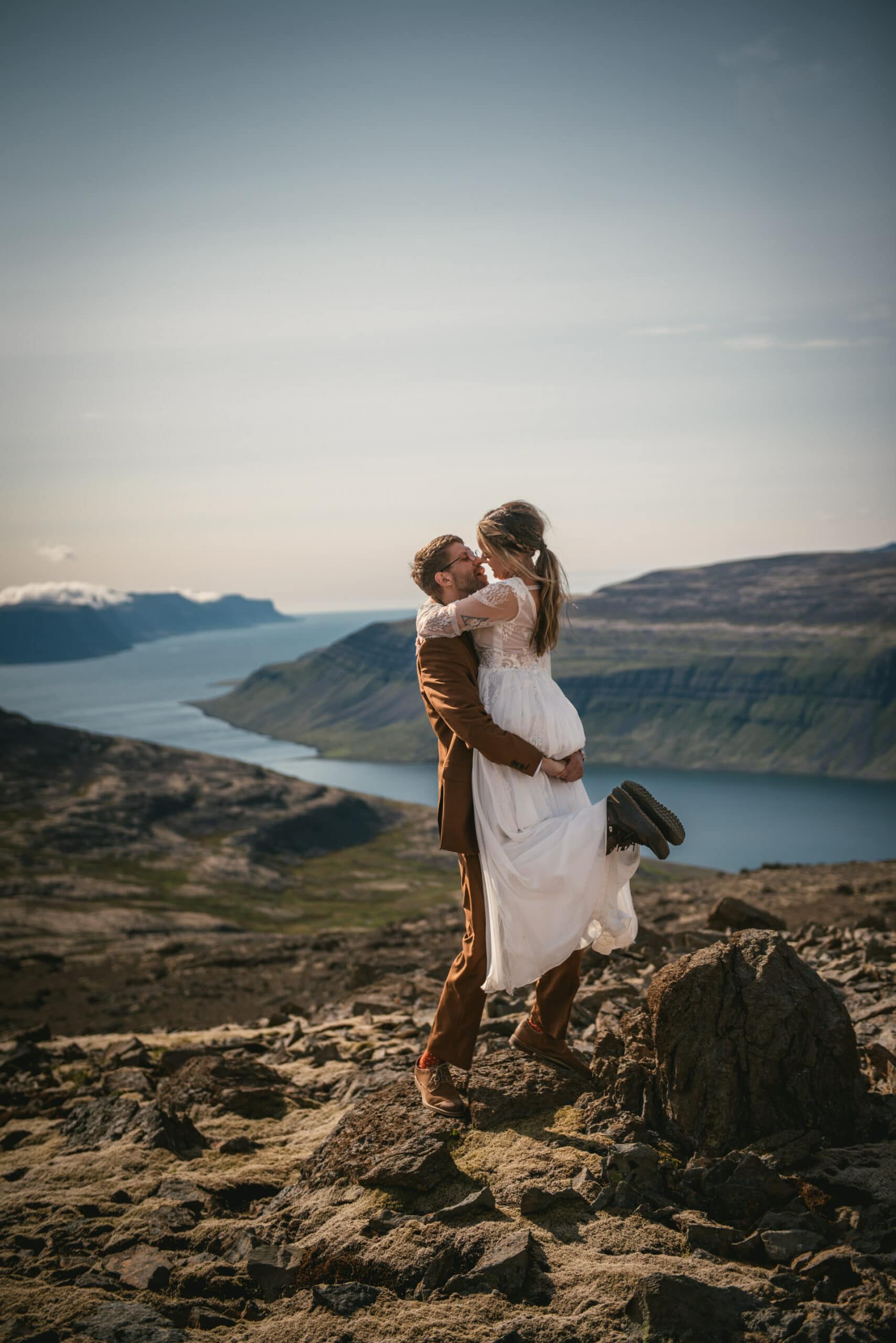 Loving embrace against a backdrop of rugged mountains and picturesque fjords.