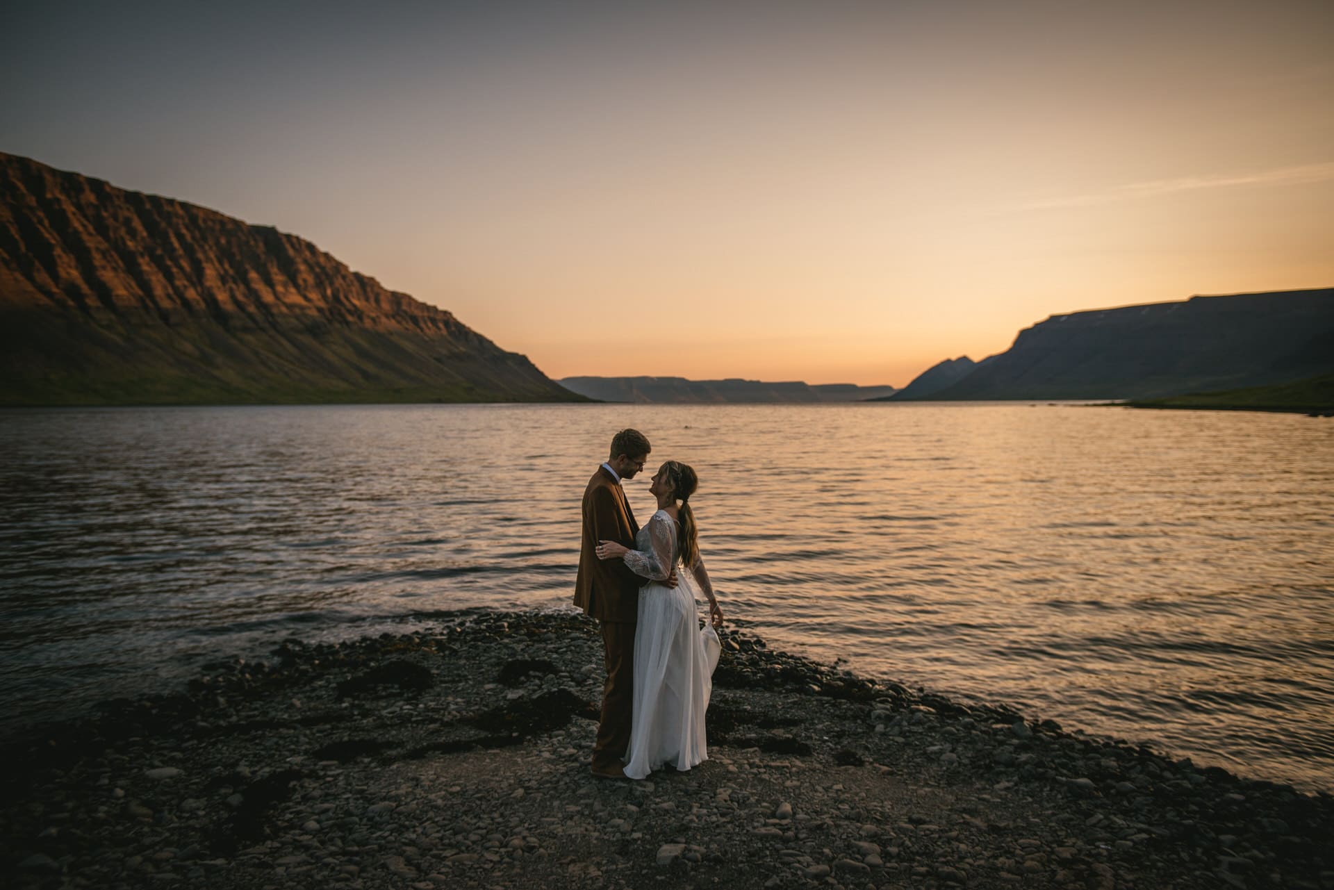 Silhouette of the couple framed against the golden hues of the Icelandic sunset.