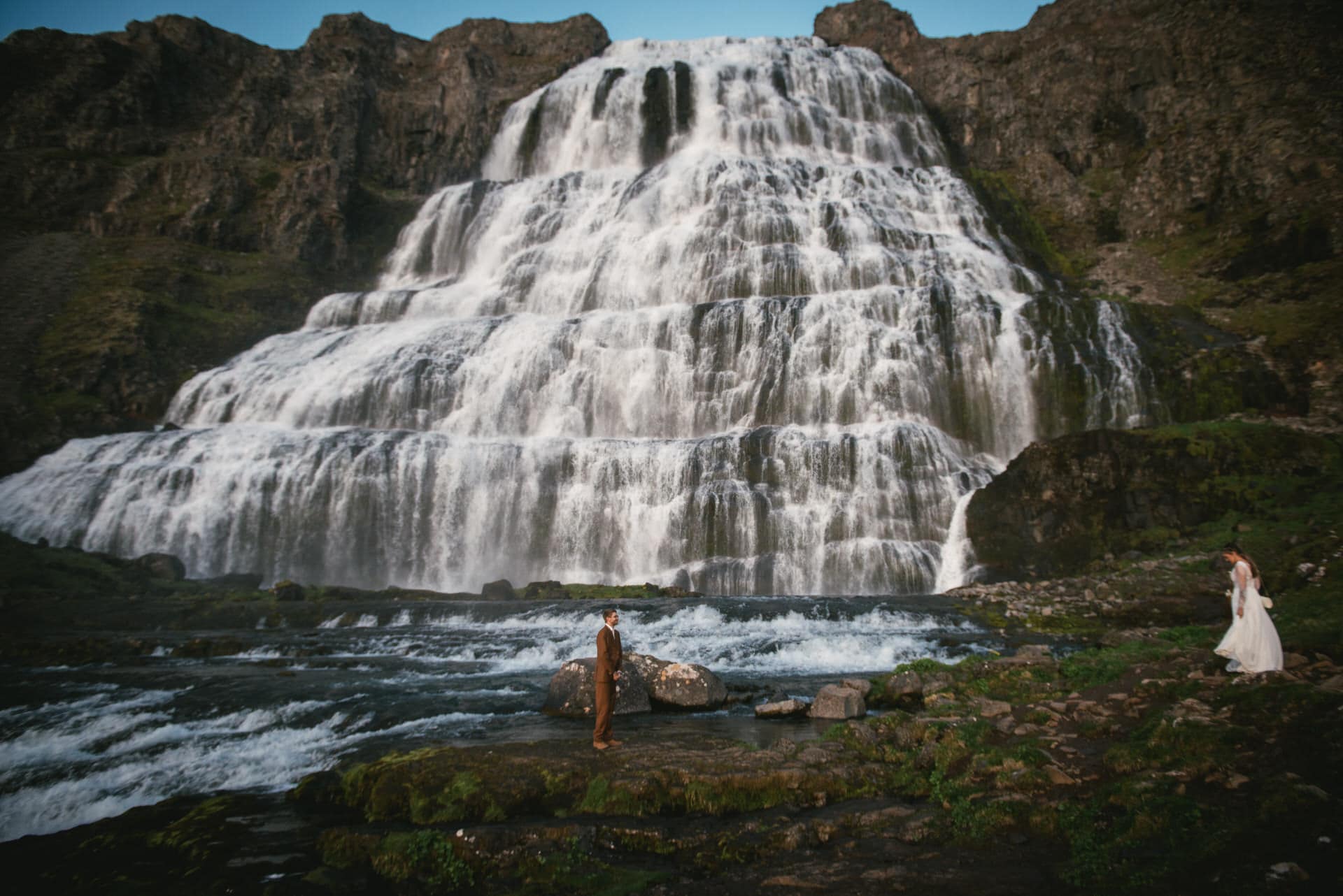 Intimate vow exchange beside a tranquil fjord, surrounded by Iceland's natural wonders.