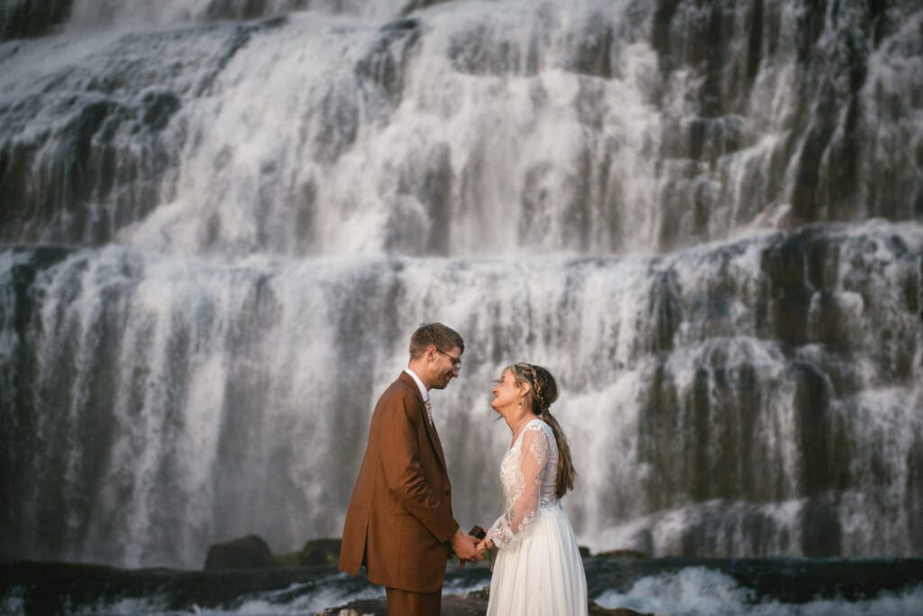 The couple's joyous laughter resonates against the backdrop of a cascading waterfall.