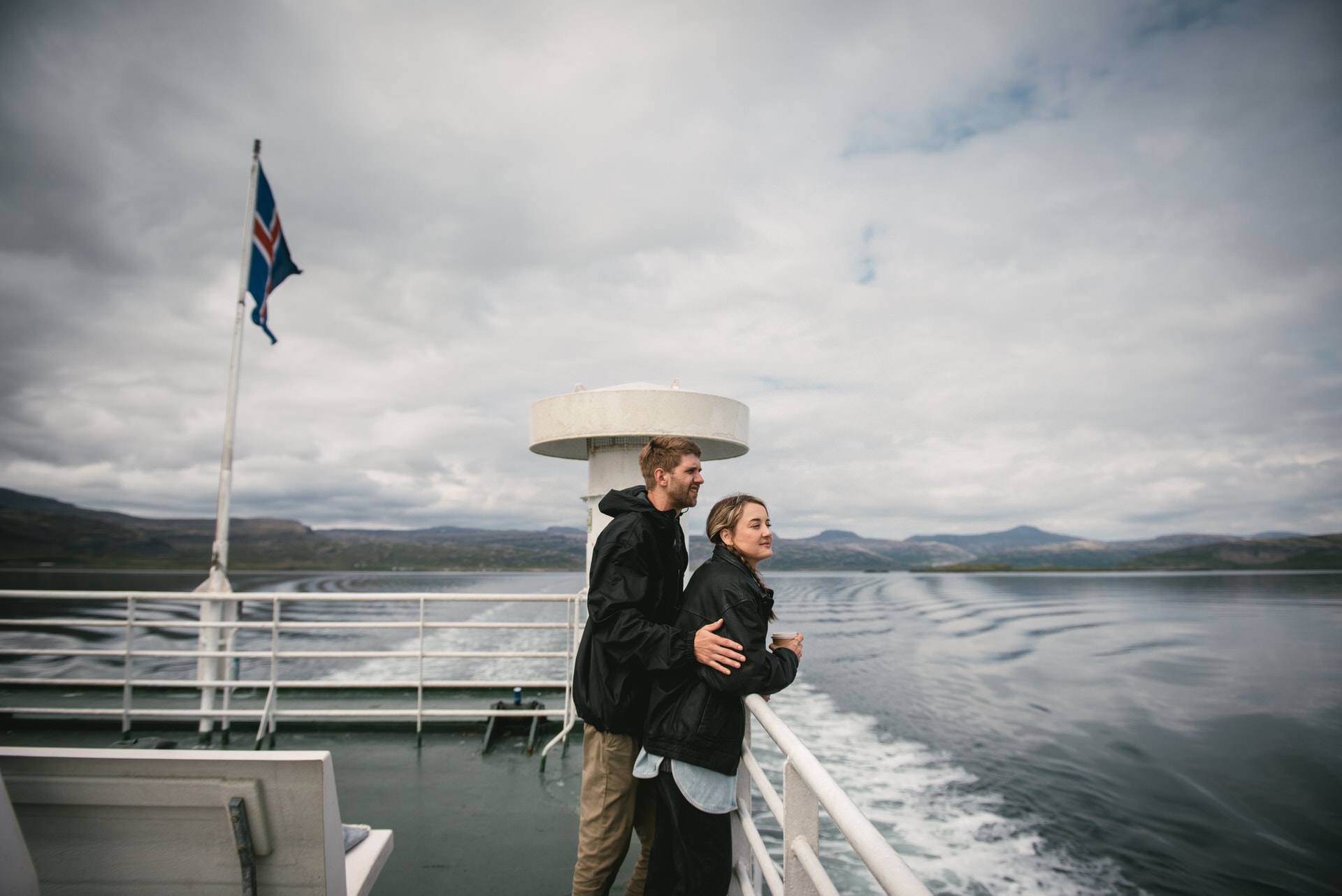 Loving embrace shared against the backdrop of Iceland's majestic fjords.
