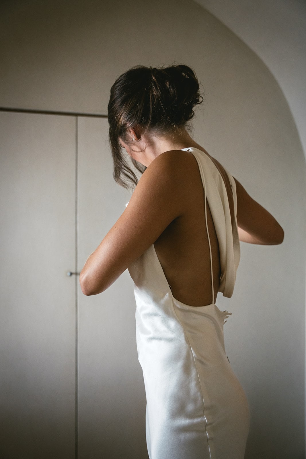 Bride donning her dress, enveloped in the elegance and anticipation of elopement