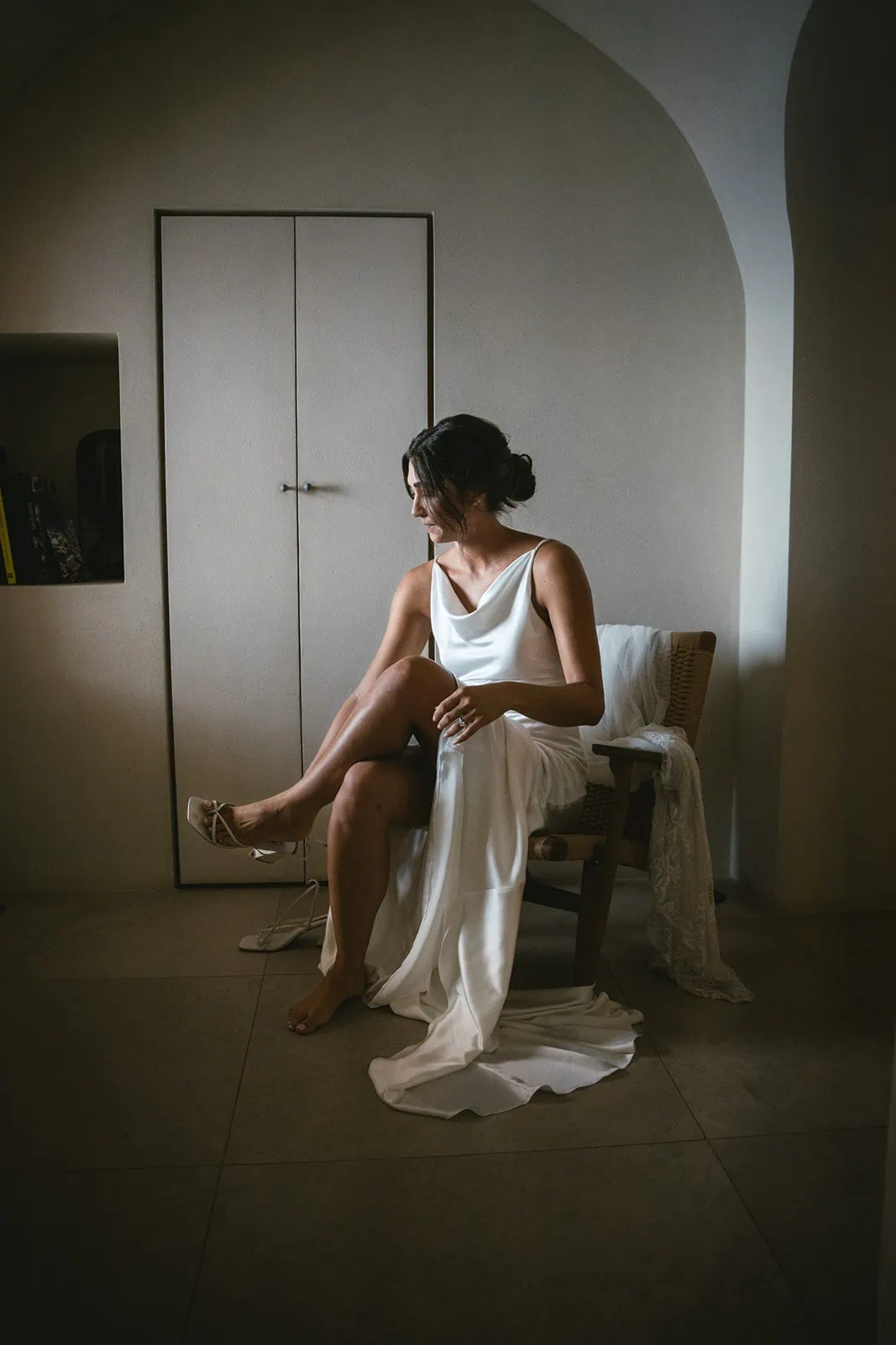 Bride slipping into her shoes, stepping closer to her soulmate and Santorini’s charm