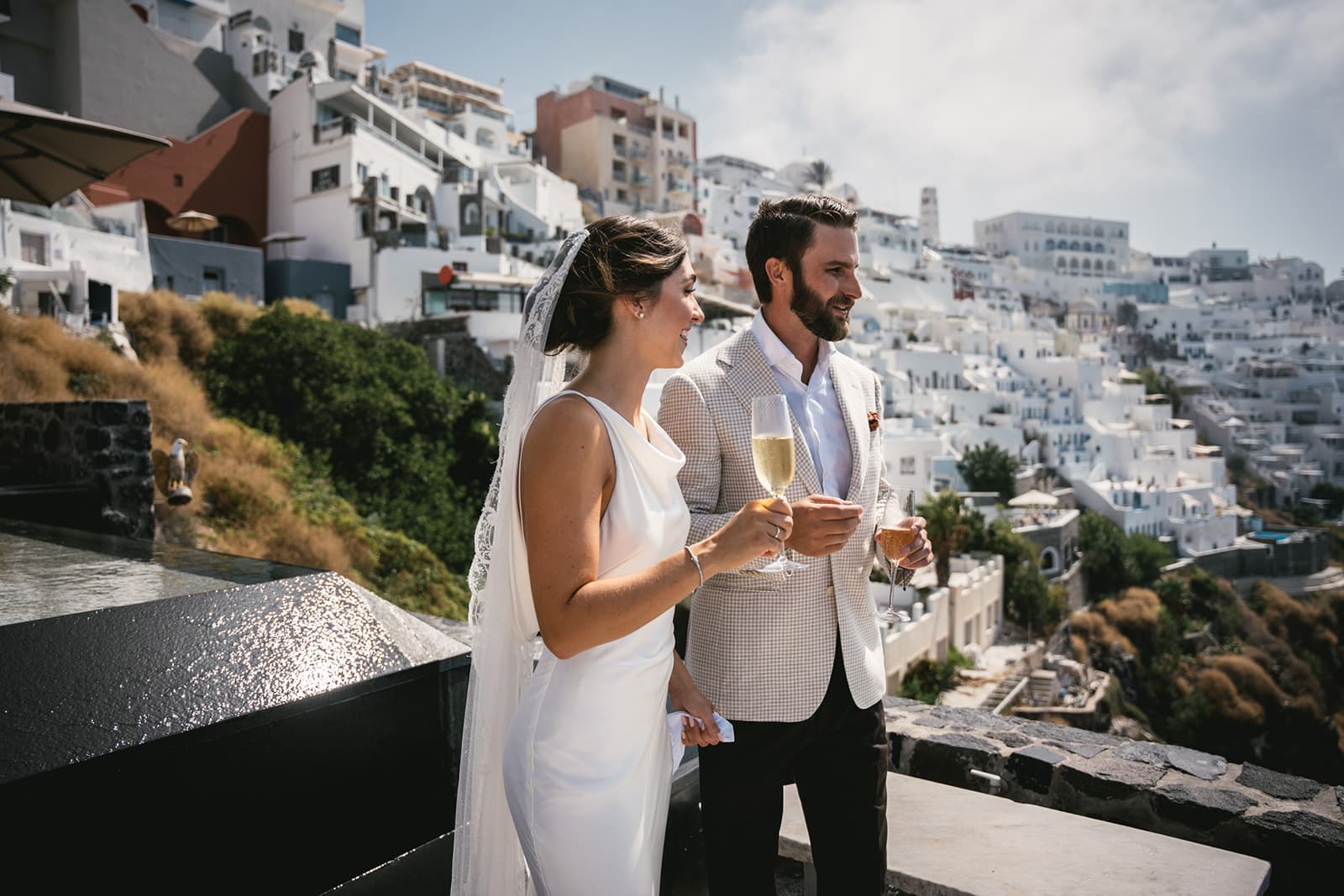 Glasses clink in celebration of love and the adventure of elopement on Santorini