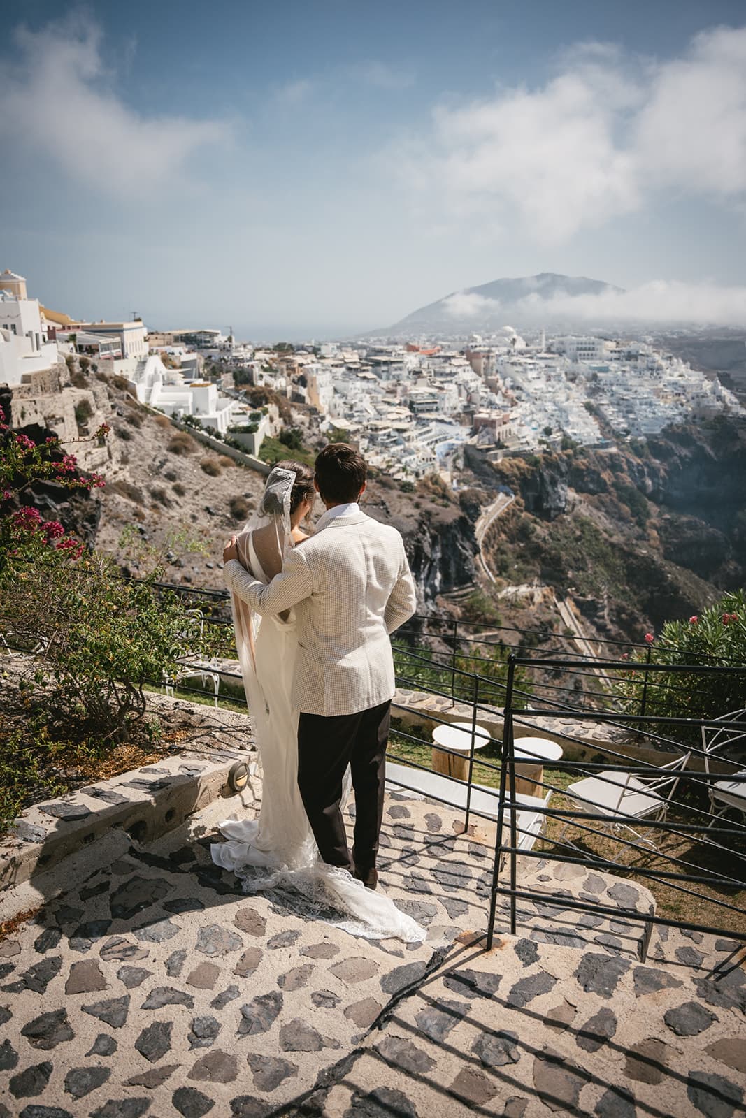 Pausing to marvel at Fira’s vistas, their elopement journey framed by infinite blue