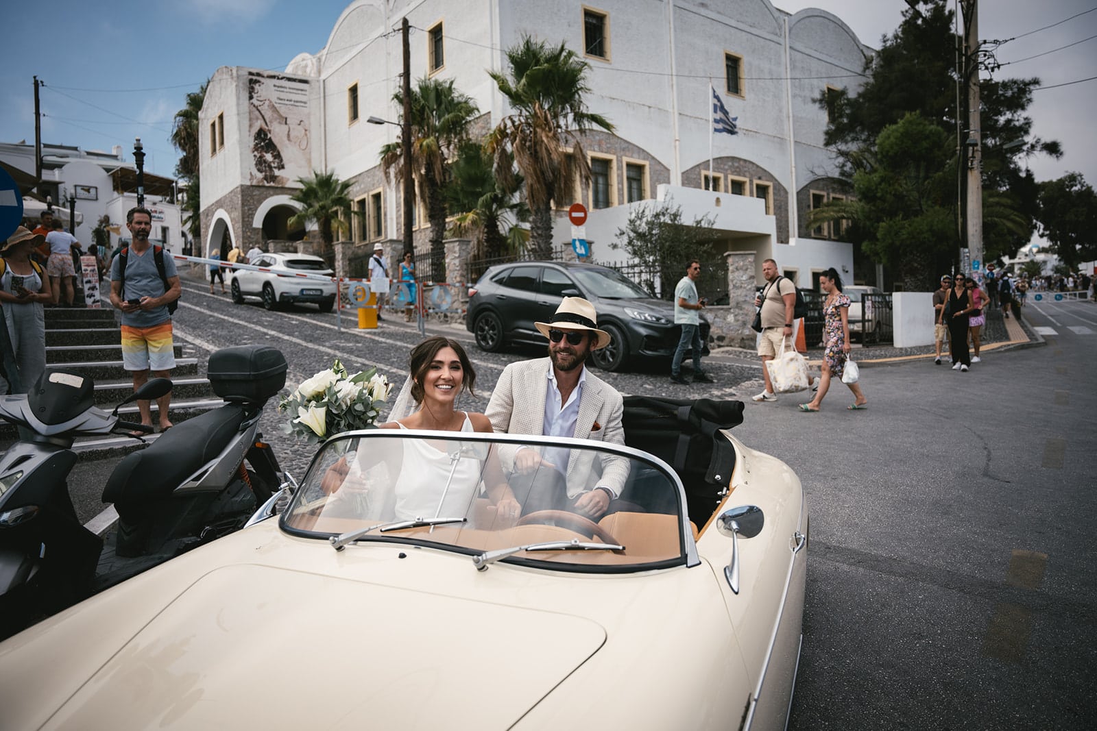 Perched above the world, their love story soars in the vintage car on Santorini’s peaks