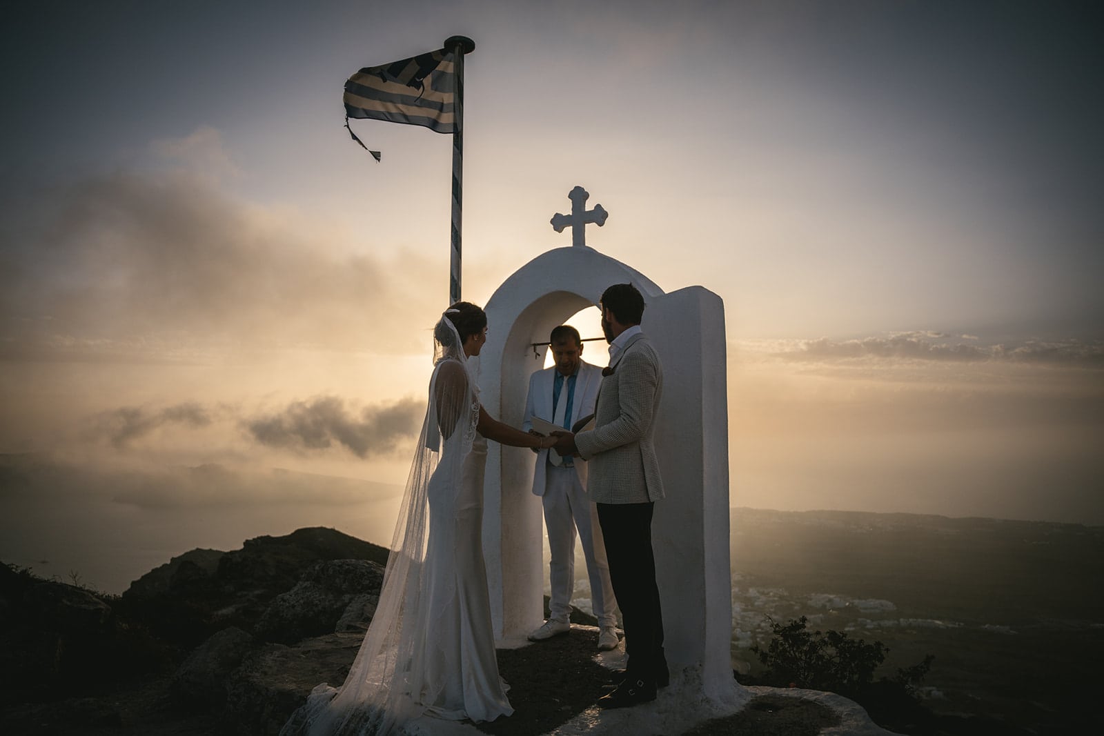 Heartfelt vows exchanged under Santorini's golden sunset, love illuminated in incredible light