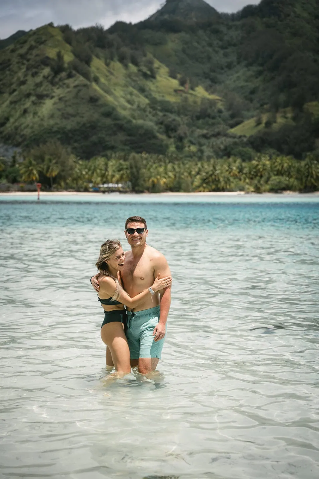 Couple looking out over the ocean, wrapped in a warm embrace during their French Polynesia elopement