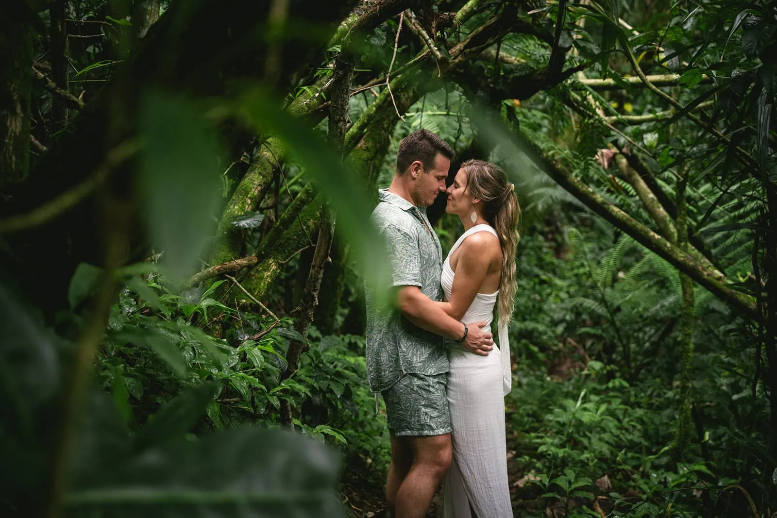 Bride and groom posing on a lush tropical path in French Polynesia