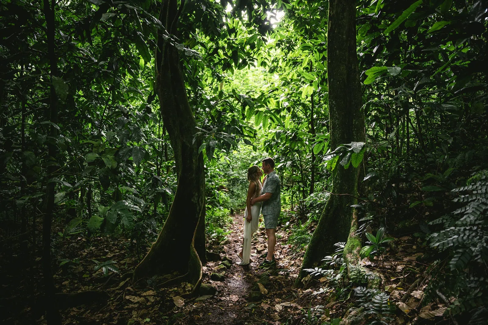 Bride and groom walking through a lush Polynesian forest, a moment of adventure