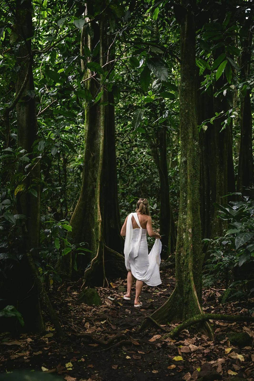 Bride walking through a lush Polynesian forest, a moment of adventure