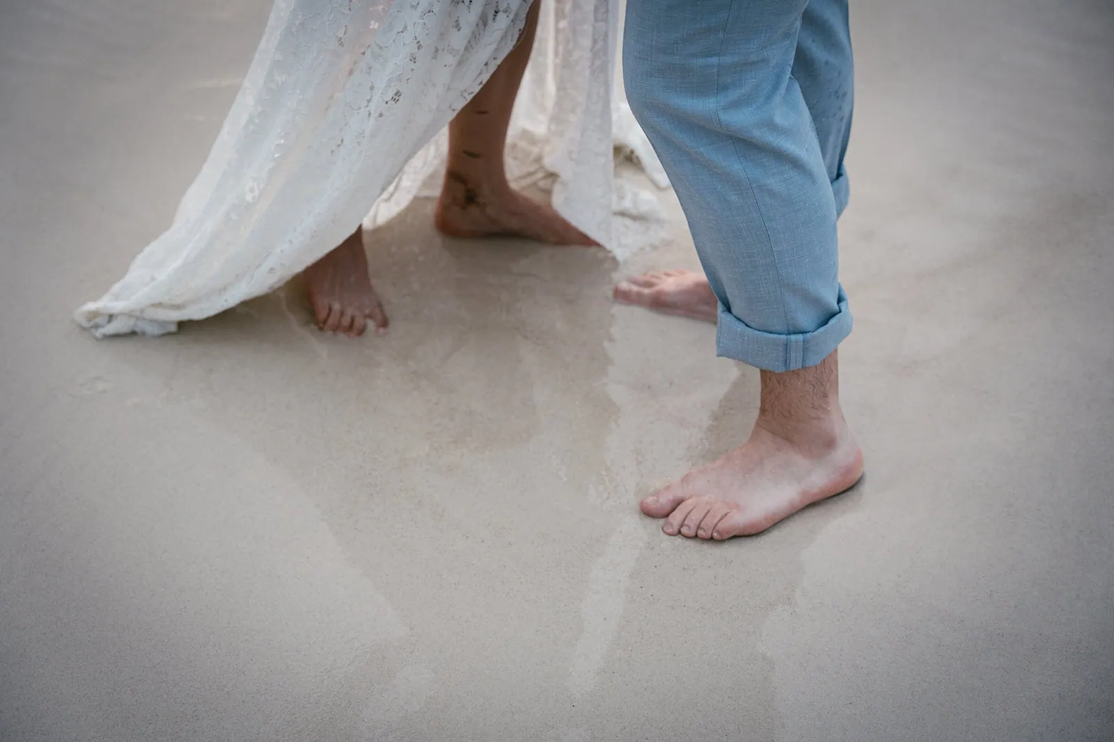 Couple's feet in the sand of French Polynesia
